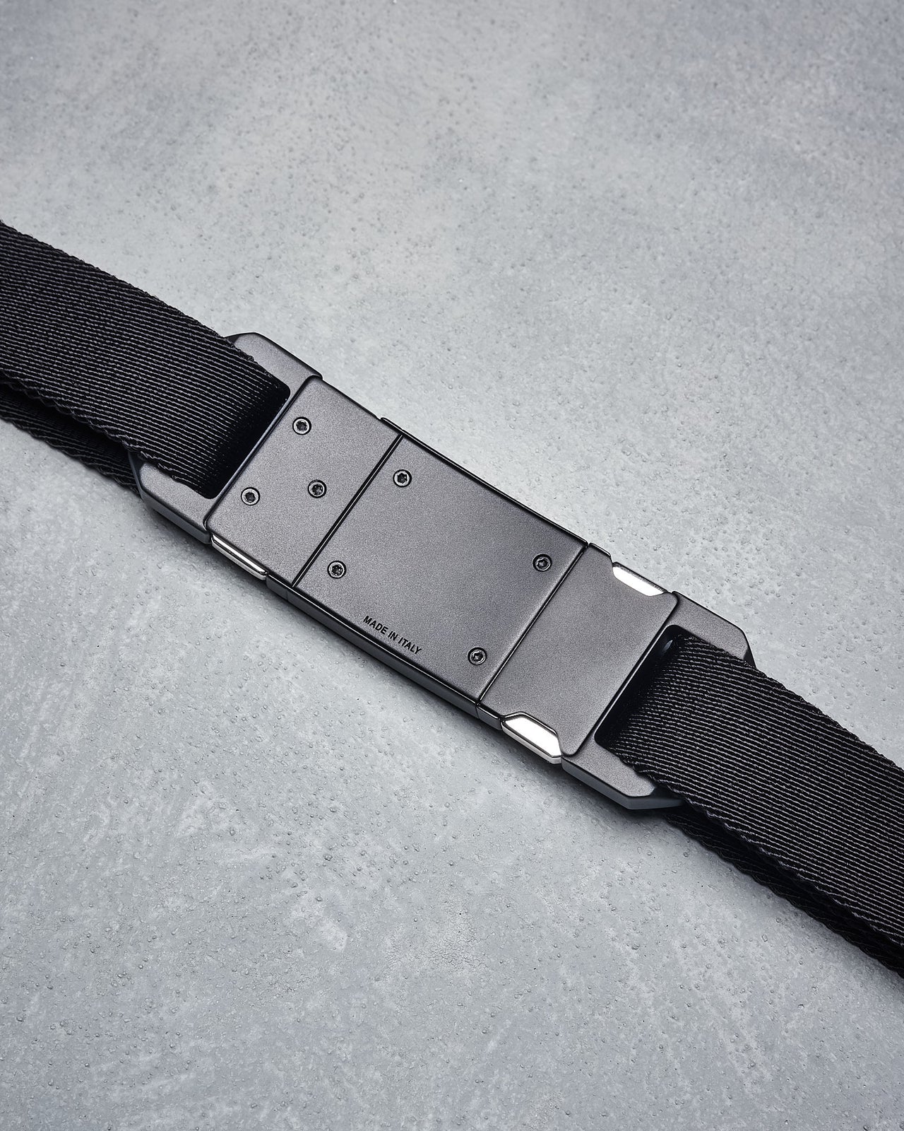 A black Dior belt with a metal buckle featuring the Dior logo, designed for men.