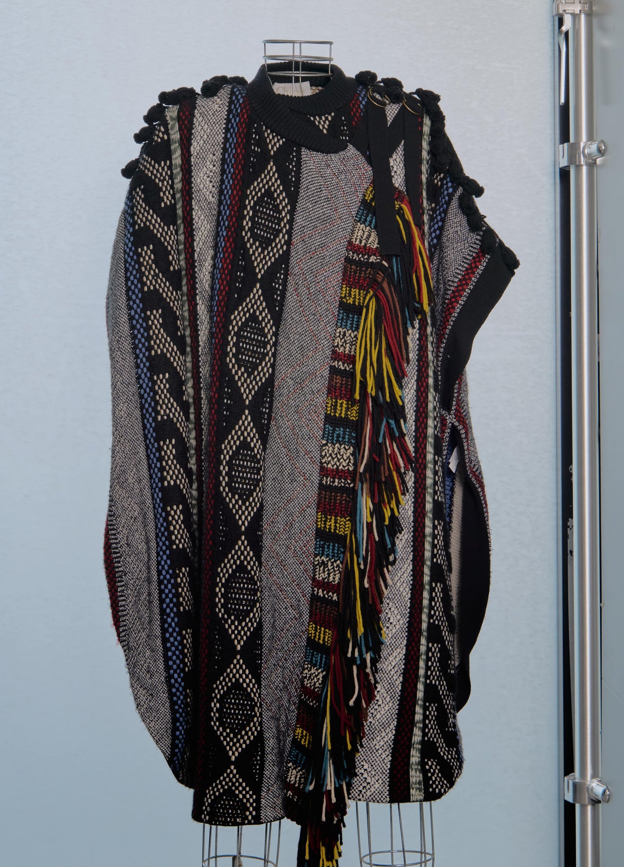 Model walking on a fashion show runway wearing a patterned Chloe poncho.