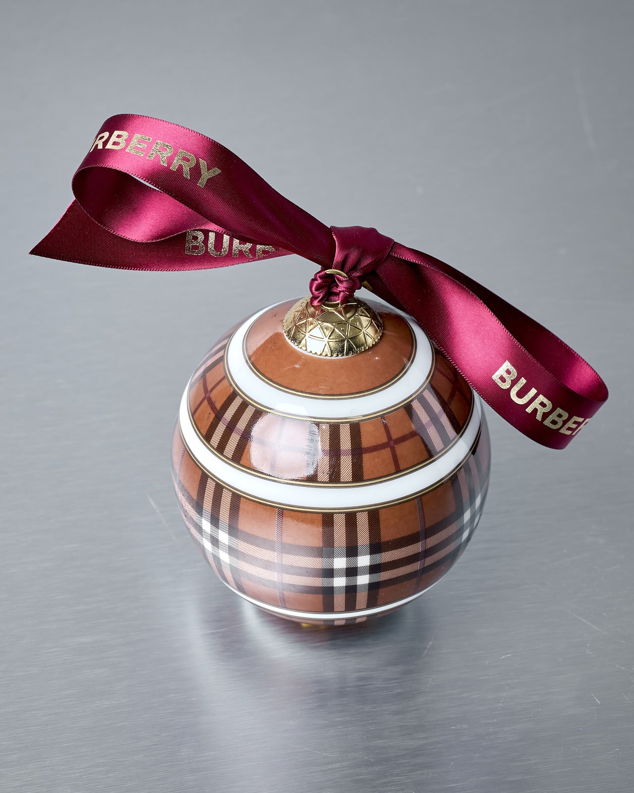 Decorative ornament with Burberry plaid pattern and ribbon on a gray background