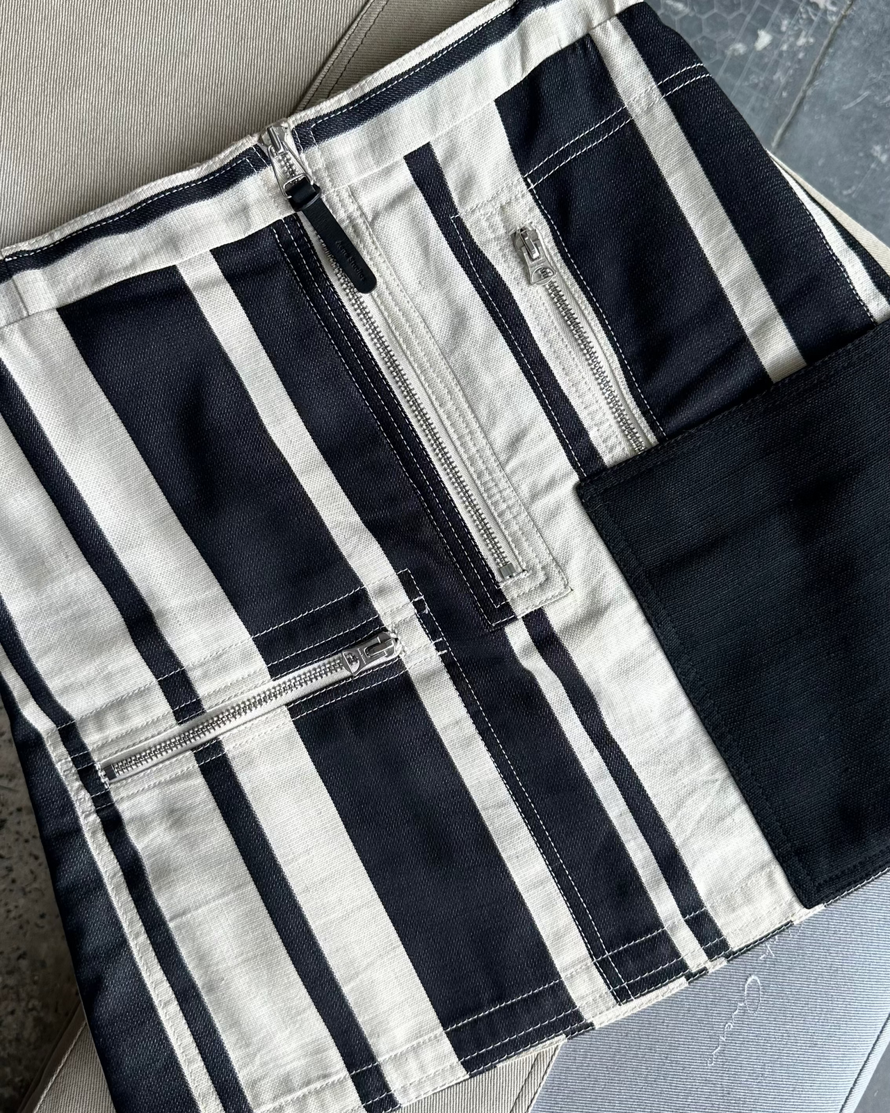 Black and white striped Acne Studios skirt on a textured surface