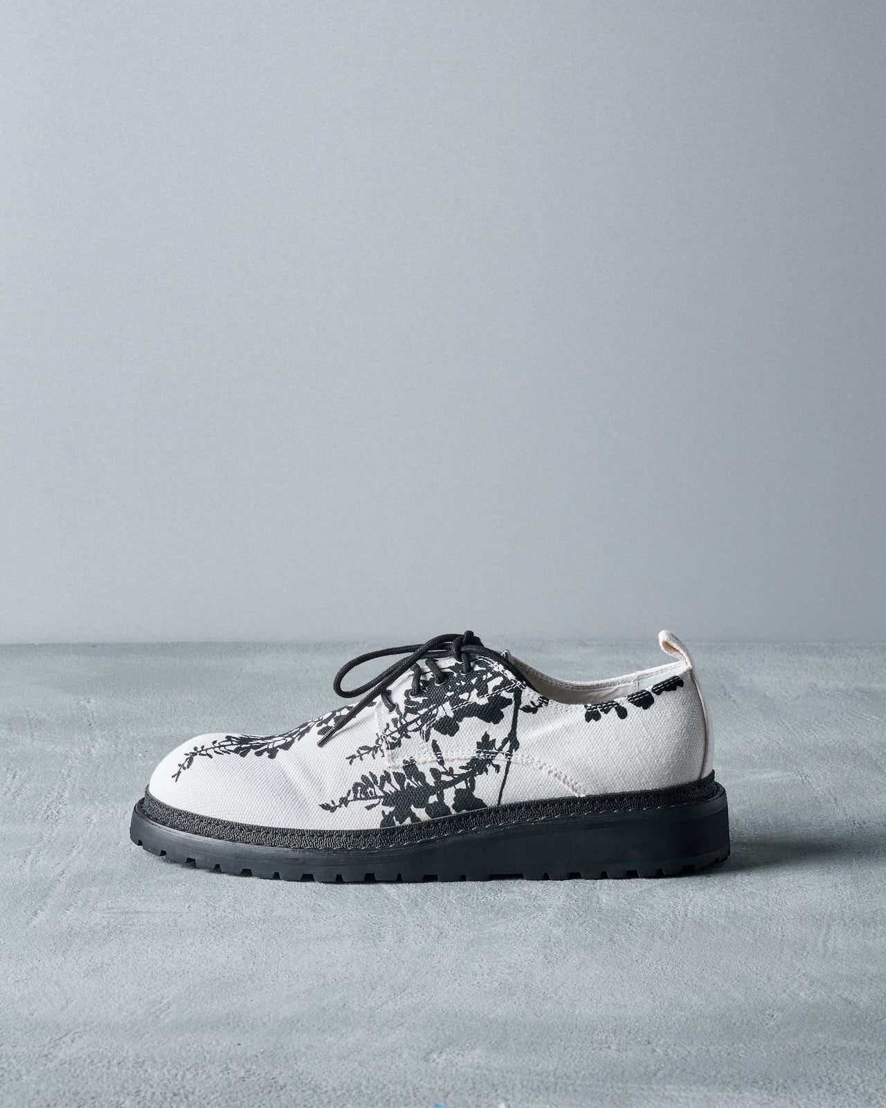 Lace-up Ann Demeulemeester derby shoes in cotton canvas with a printed floral motif, featuring black-and-white detailing and chunky padded soles.