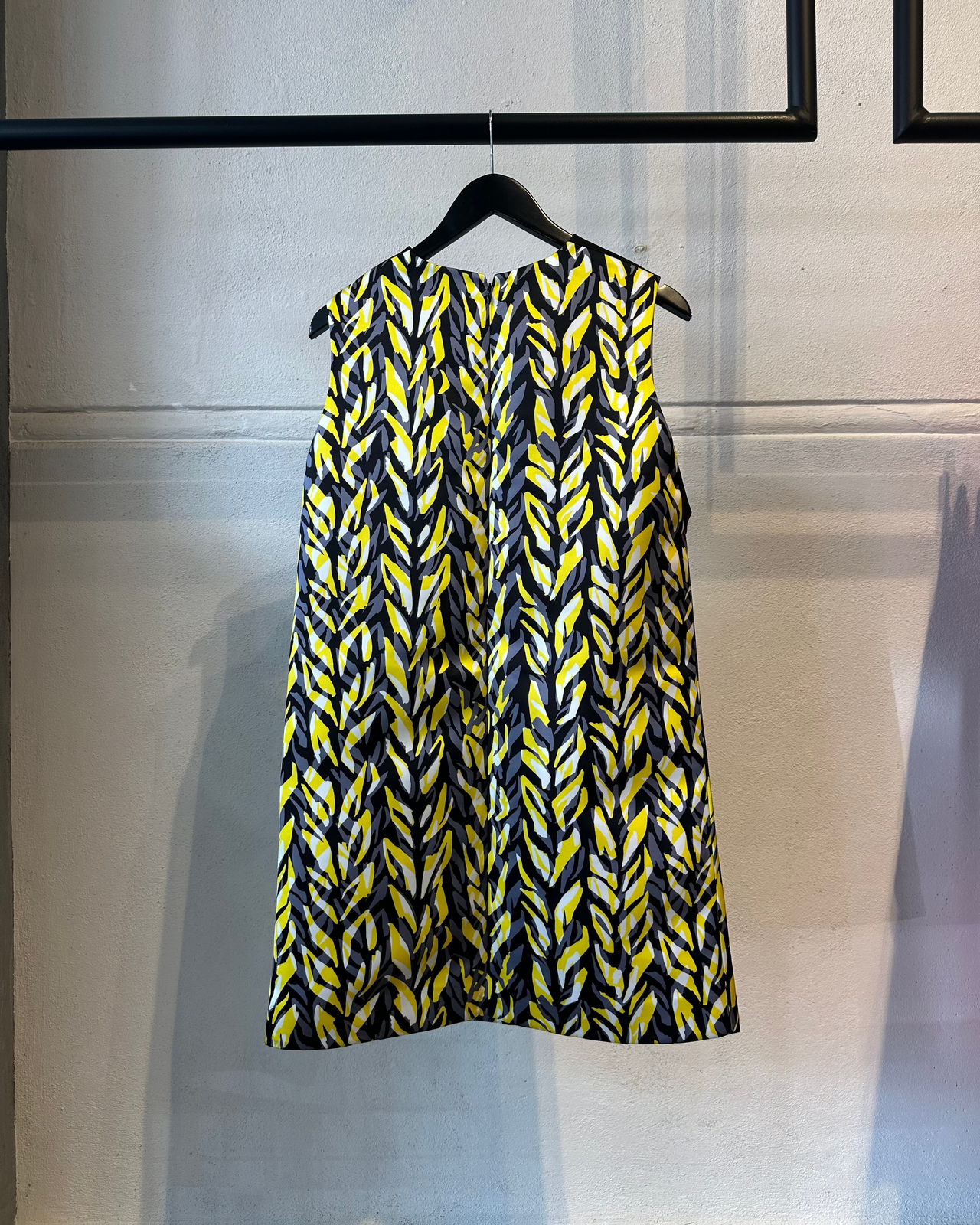 Black and yellow Balenciaga patterned dress on a hanger against a neutral background