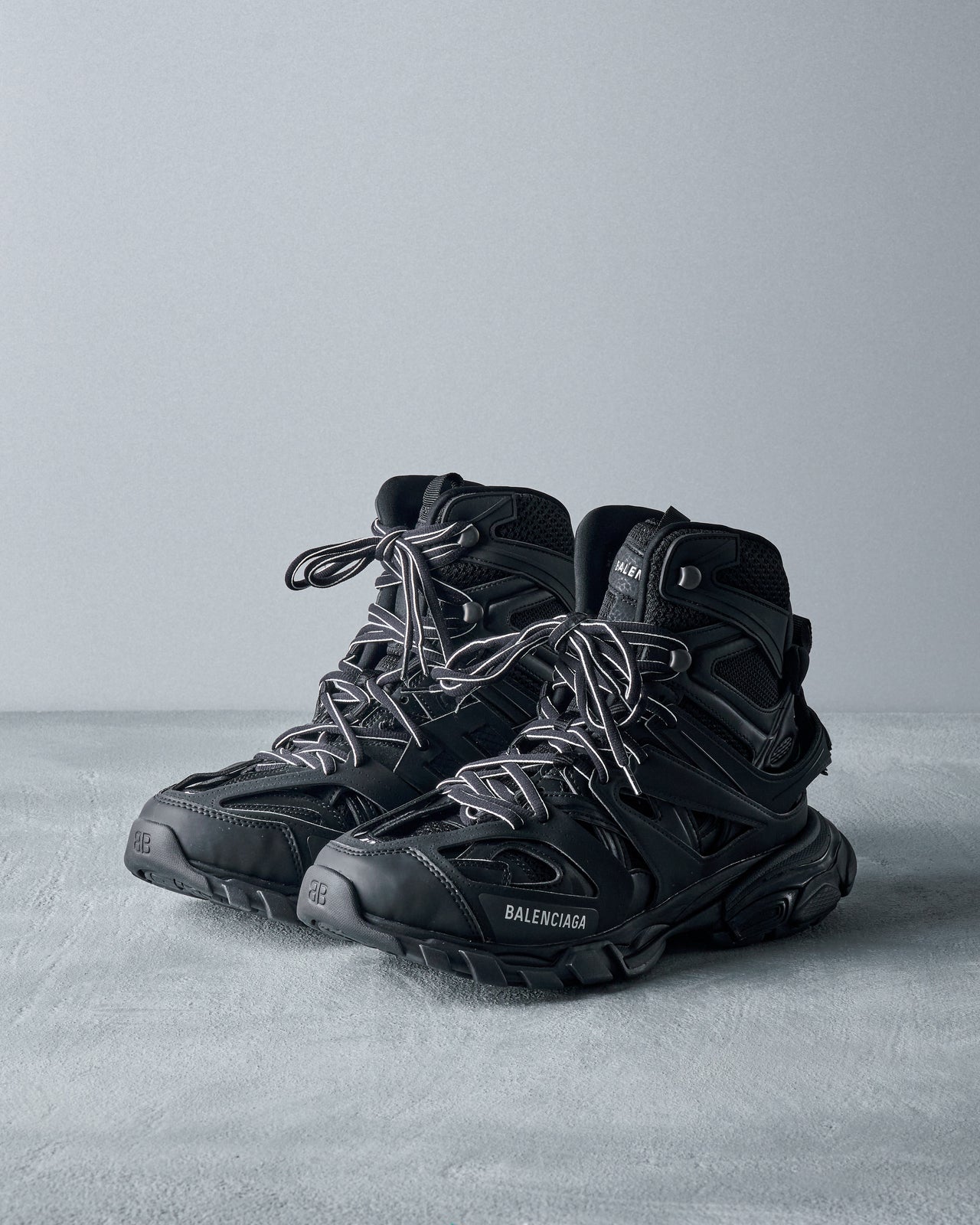 A pair of black Balenciaga Track hike sneakers with lace-up closure, featuring mesh fabric and padded inner.