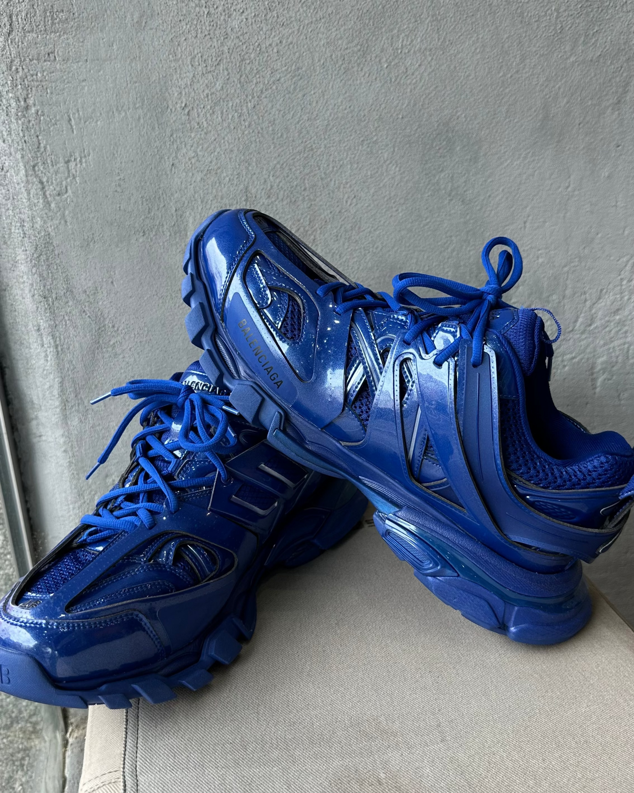 Blue Balenciaga sneaker on a gray surface with a neutral background