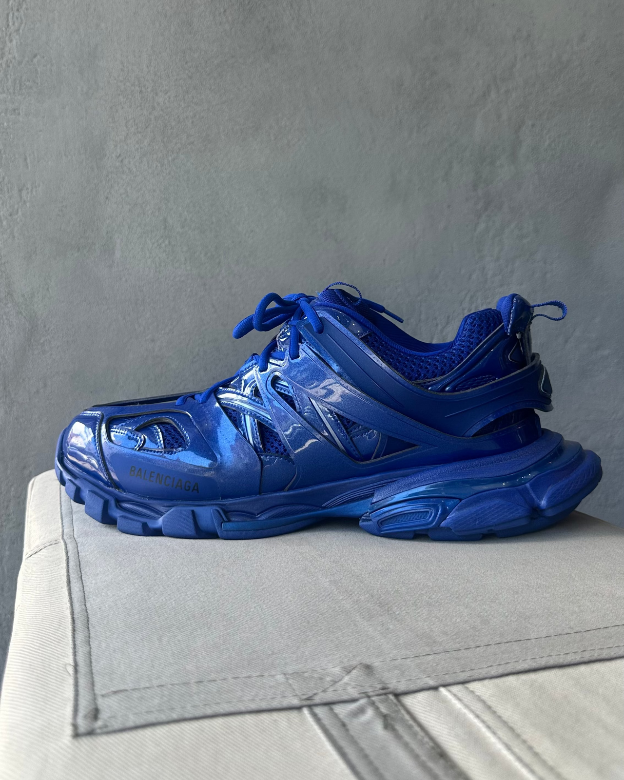Blue Balenciaga sneaker on a gray surface with a neutral background