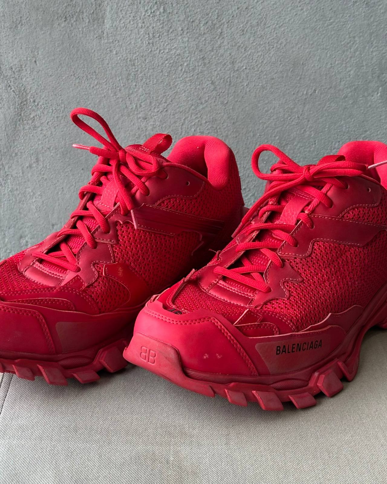 Red Balenciaga sneaker on a light gray surface with a neutral background