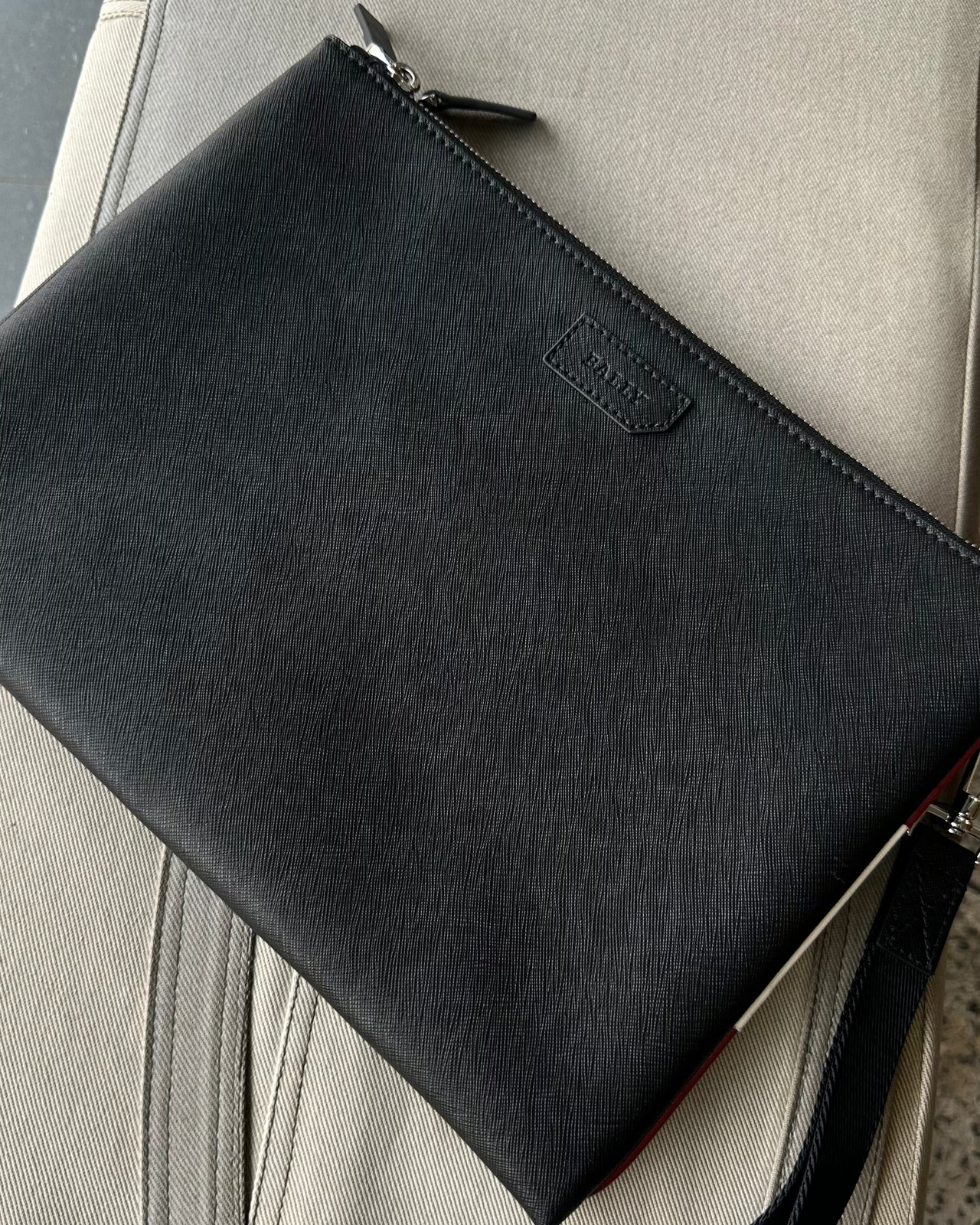 Black Bally clutch bag on a textured surface