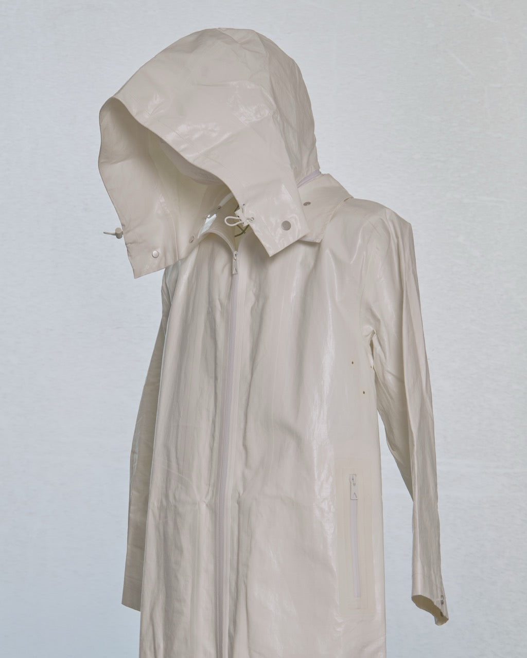 White Bottega Veneta trench coat on a mannequin against a light gray background