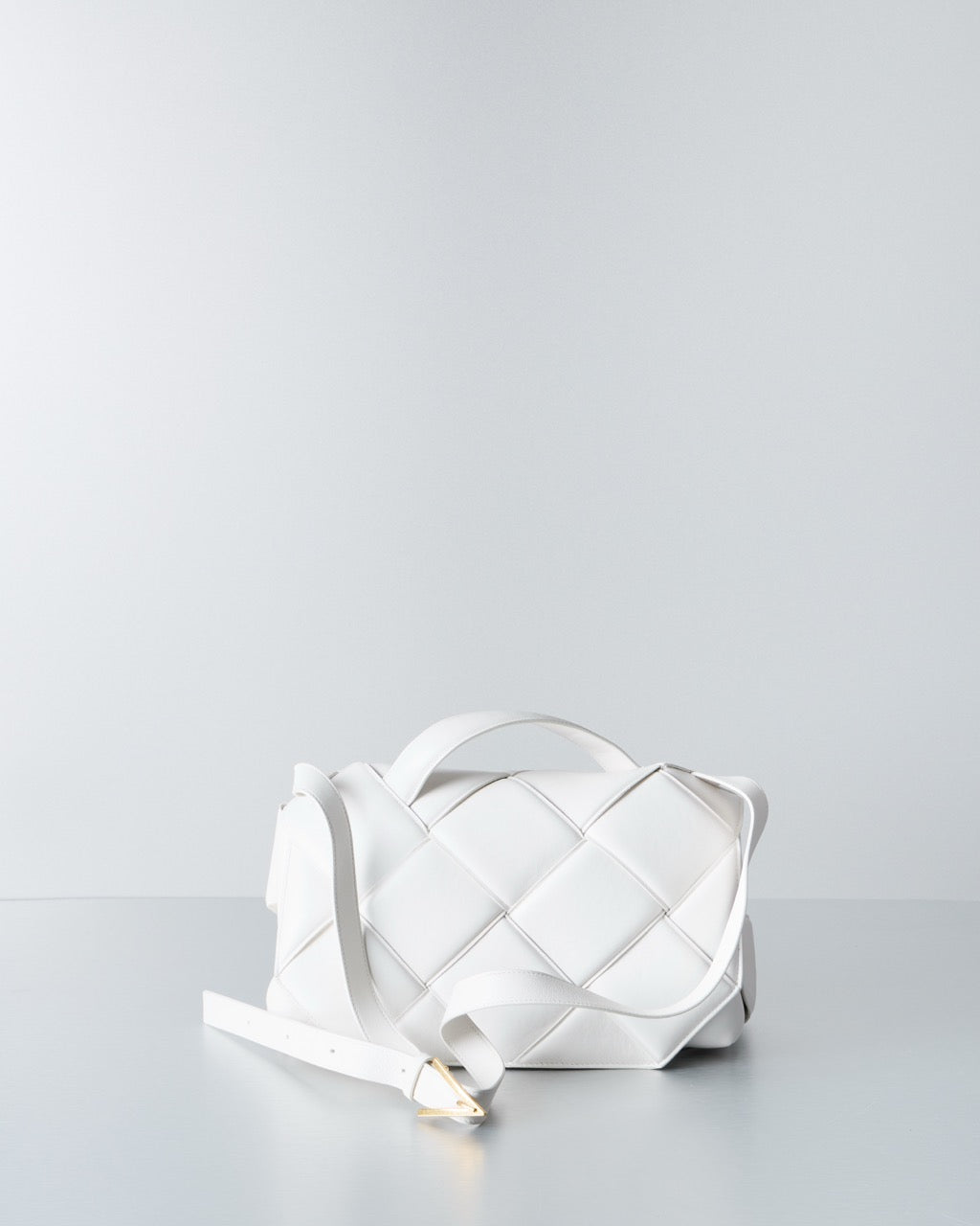 White quilted Bottega Veneta handbag on a light gray background