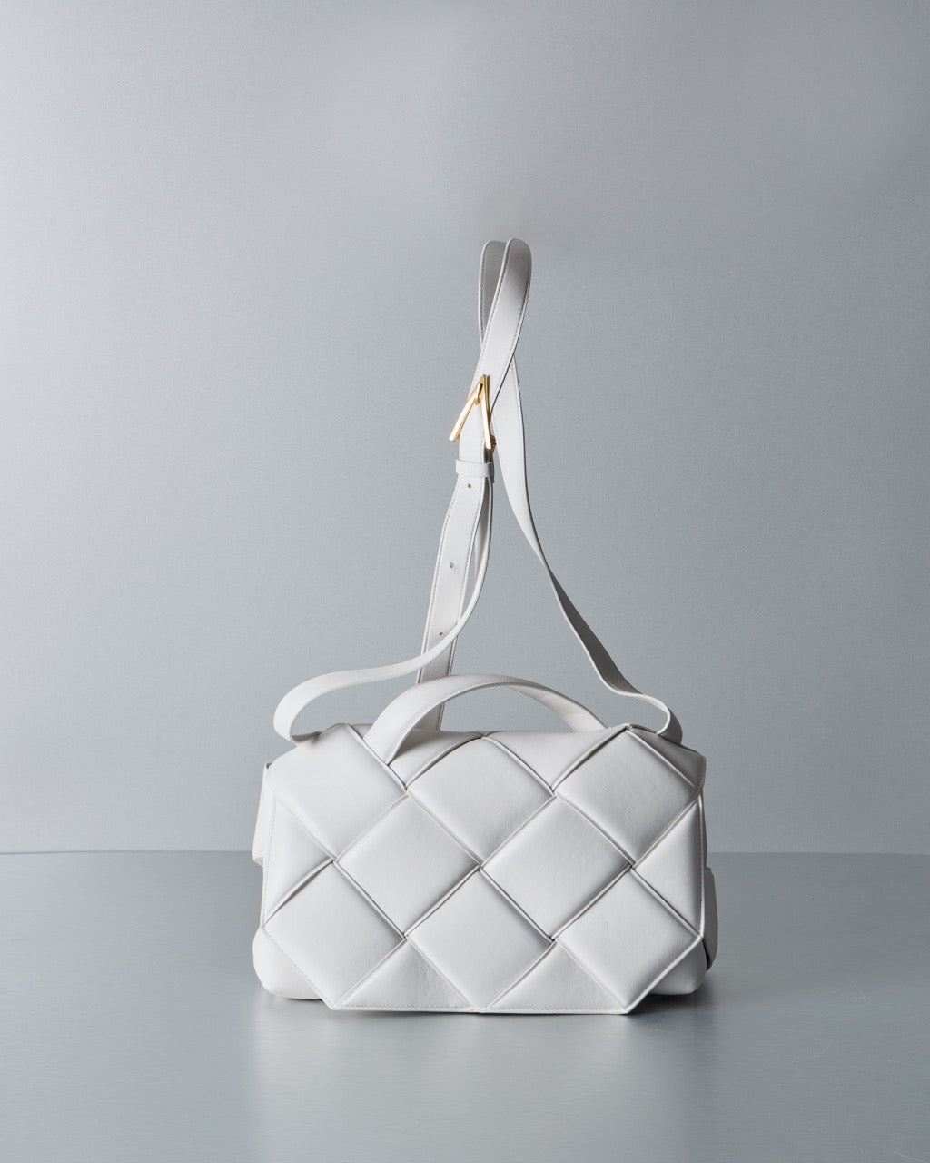 White quilted Bottega Veneta handbag on a light gray background