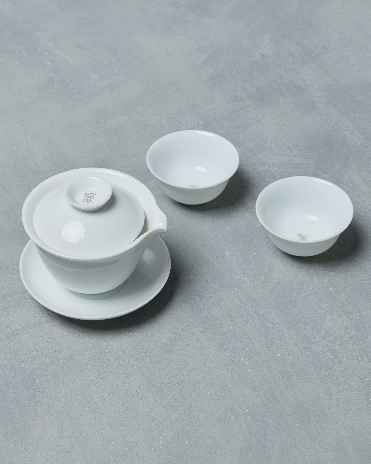White ceramic Burberry tea set on a grey surface