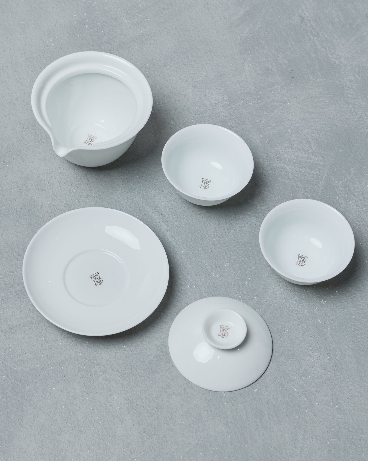 White ceramic Burberry tea set on a grey surface