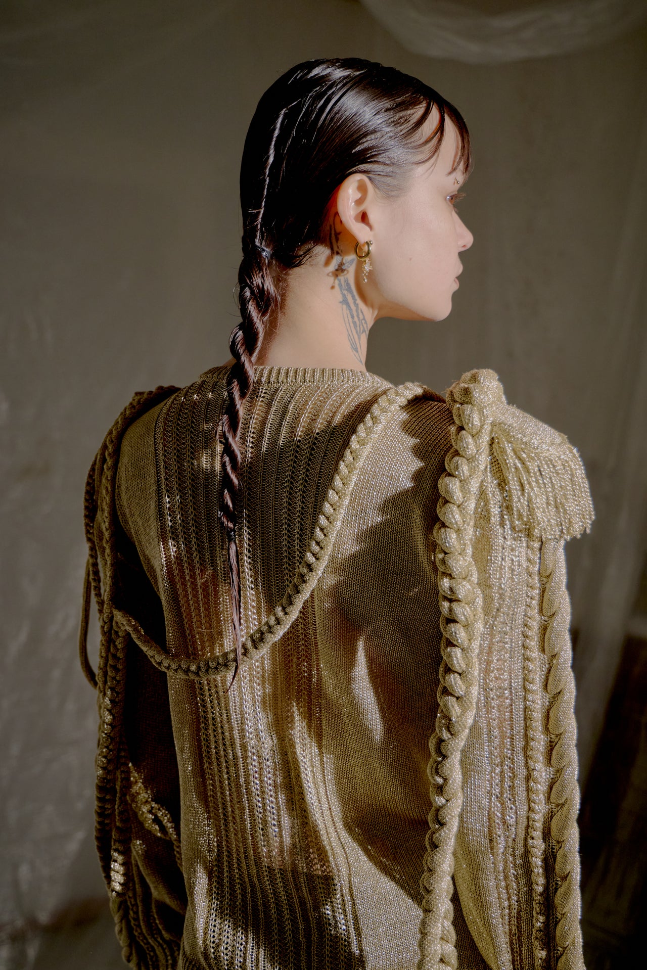 Person wearing a textured gold Burberry sweater against a neutral background