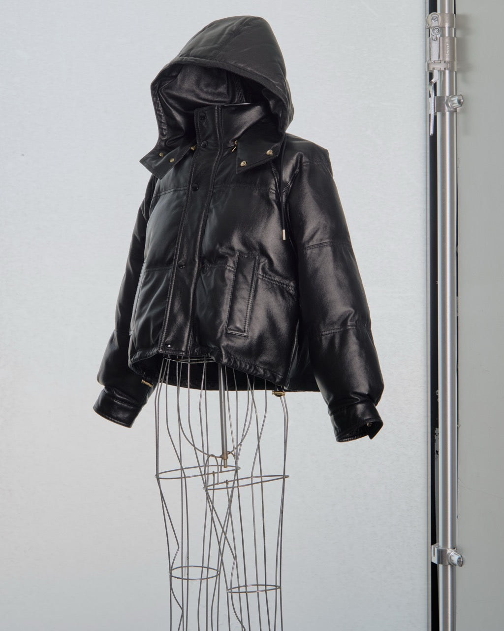Black leather Celine jacket on a mannequin against a plain background