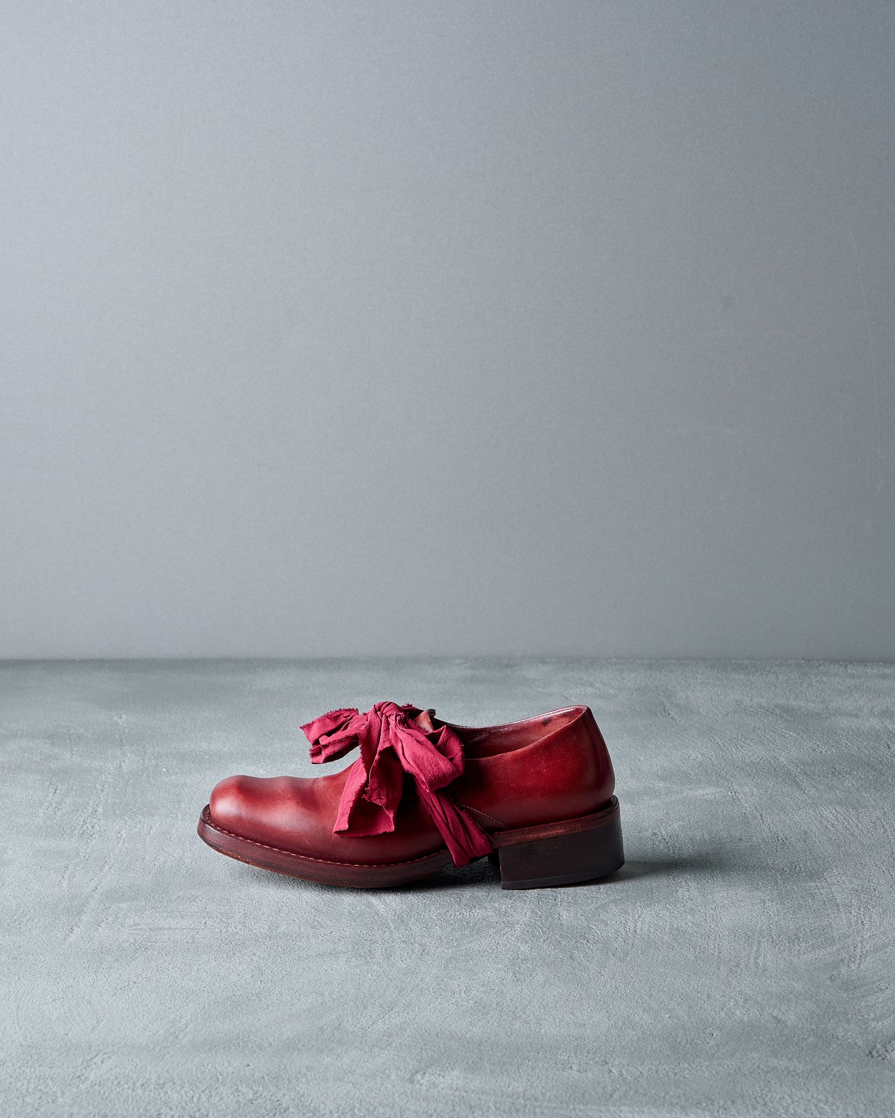 Red Cherevichkiotvichki shoe with ruffles on a gray background