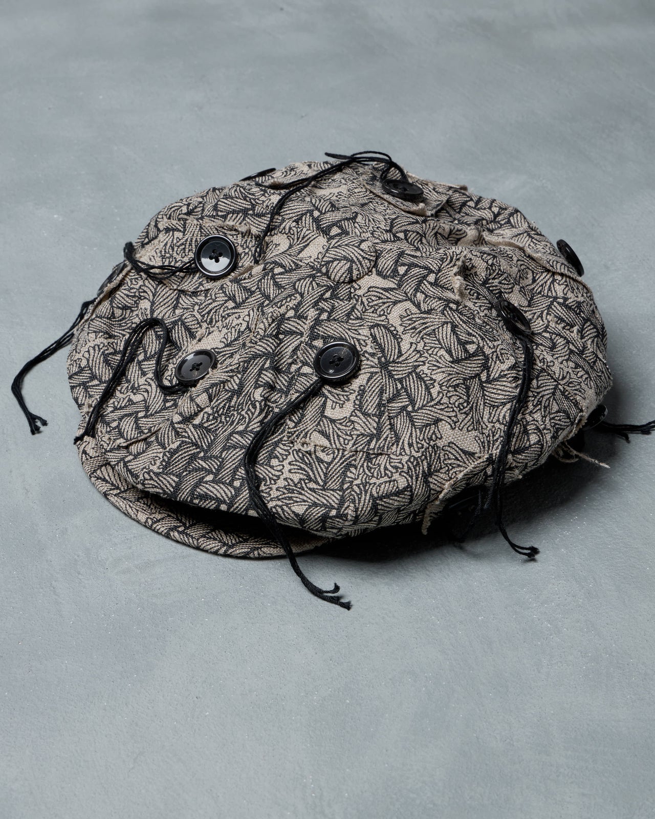 Round Christopher Nemeth hat black pattern on a gray background