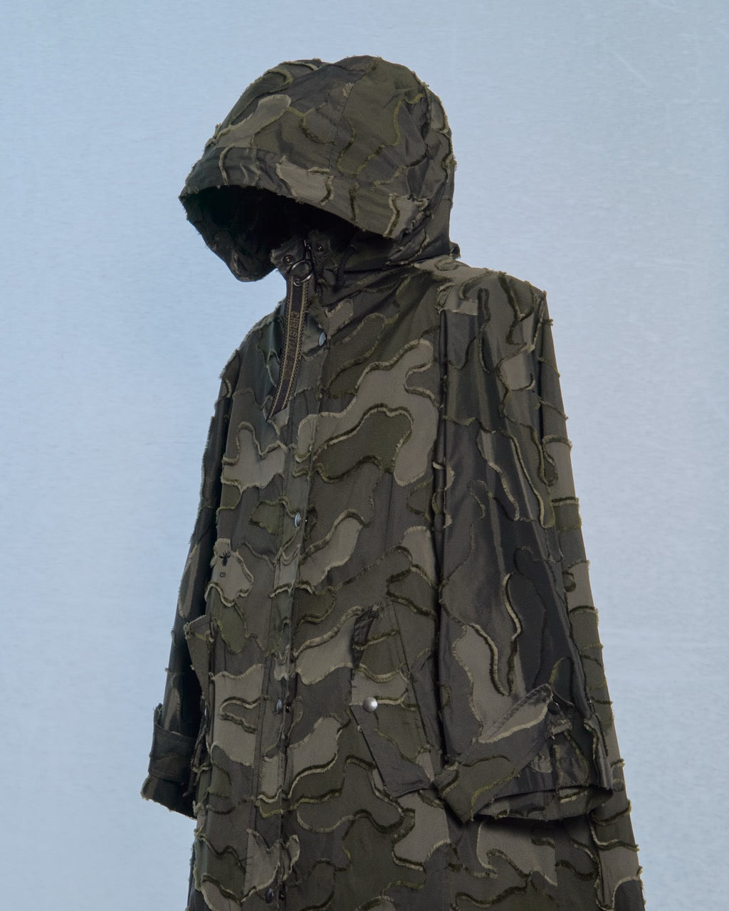 Model on a Dior runway wearing a patterned outfit with a dark background