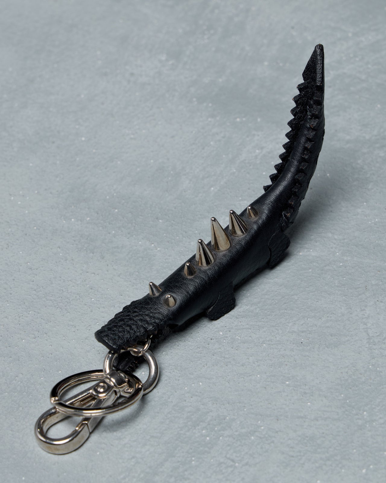 Black Fendi spiked keychain on a gray background