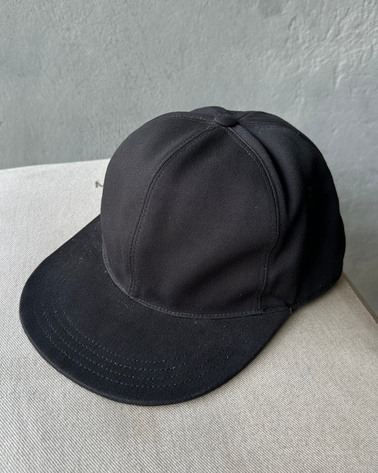 Black Givenchy cap on a textured surface with a gray background