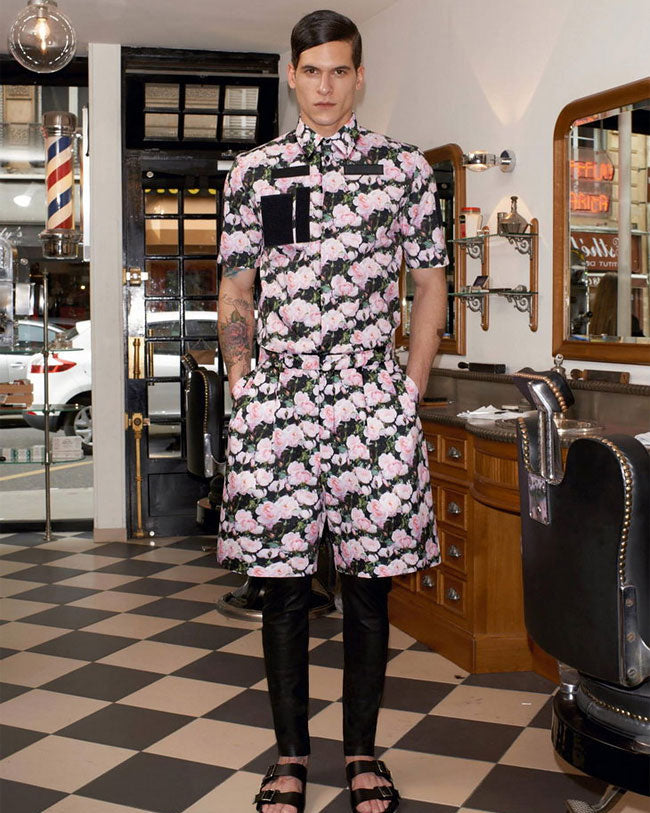 Person wearing a floral Givenchy outfit in a barbershop setting