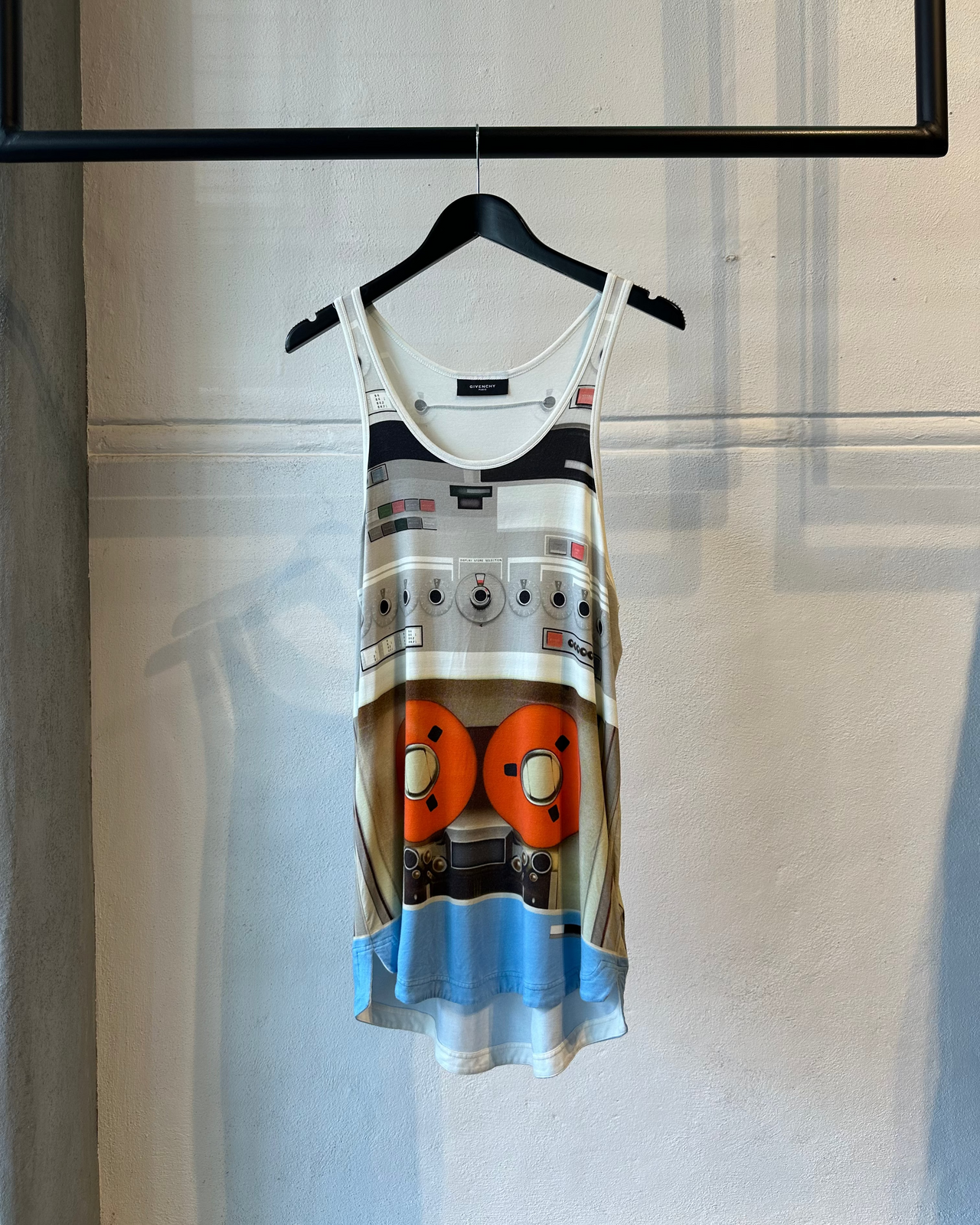 Model walking on a Givenchy runway wearing a unique tank top and colorful socks.