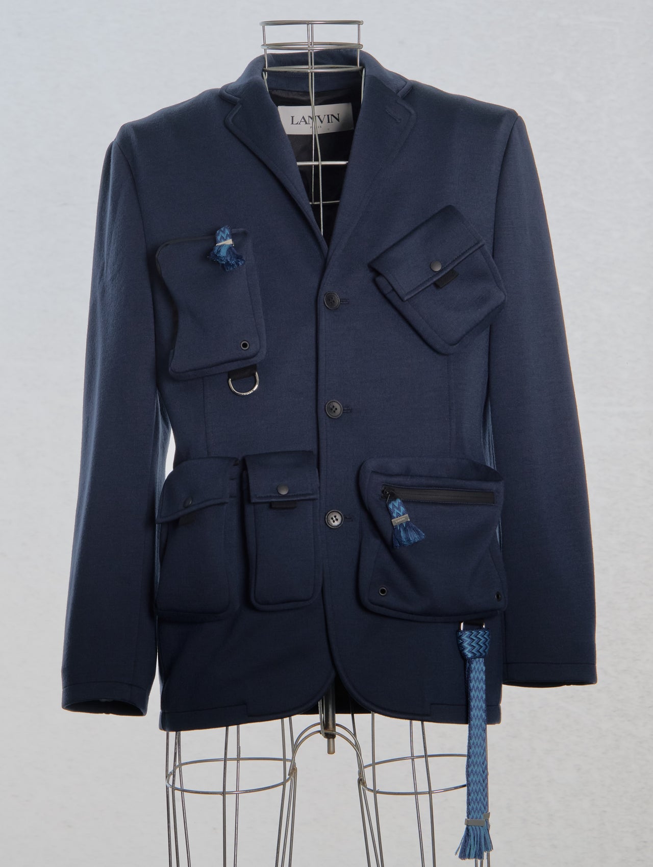 Navy blue Lanvin blazer with multiple pockets on a mannequin against a light gray background