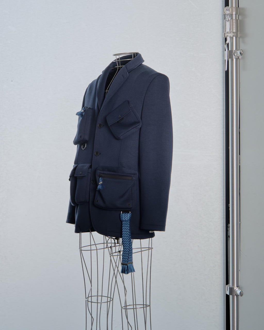 Navy blue Lanvin blazer with multiple pockets on a mannequin against a light gray background