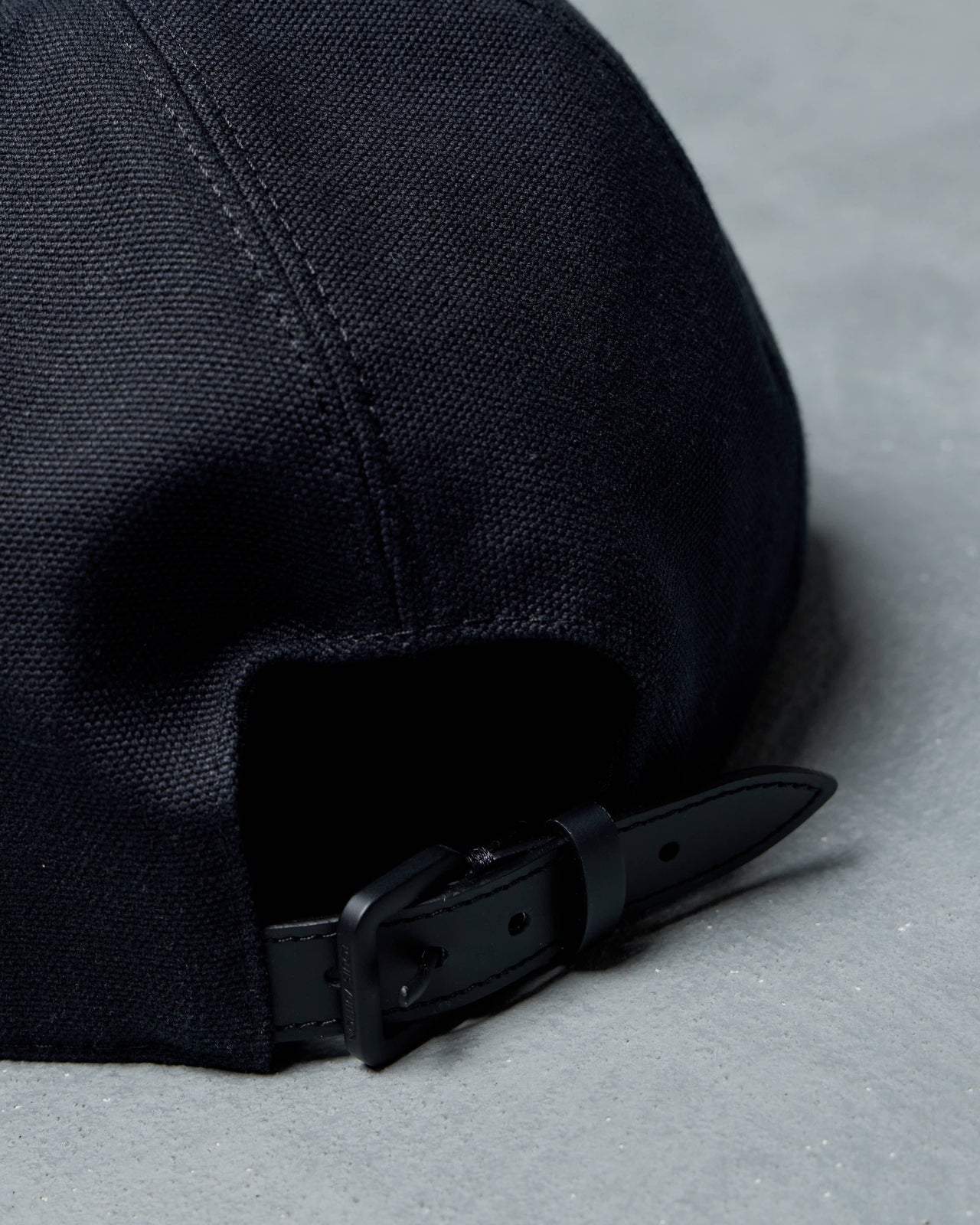 Black Louis Vuitton cap with a logo on a gray background