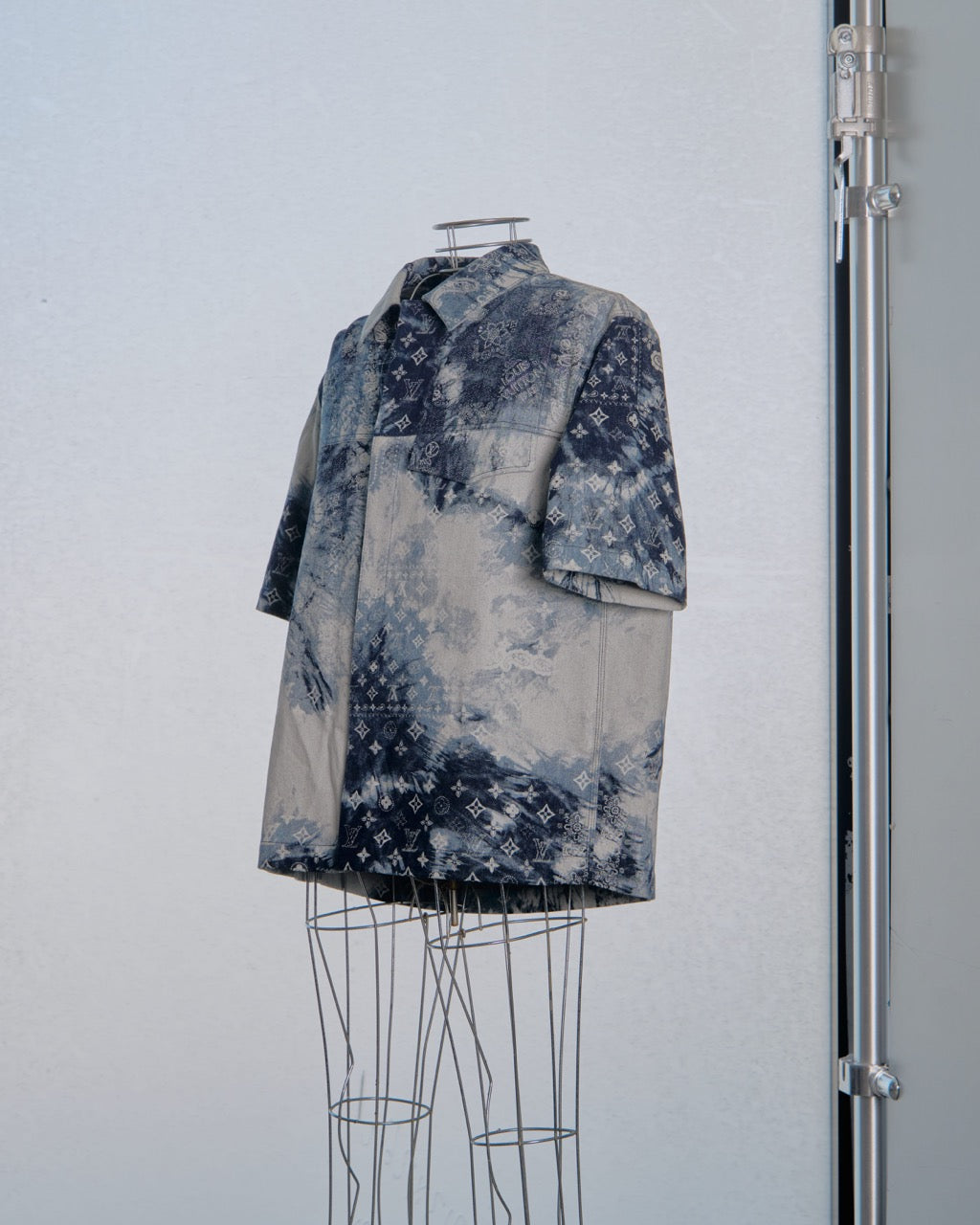 Short-sleeve Louis Vuitton shirt with a pattern on a mannequin against a light blue background