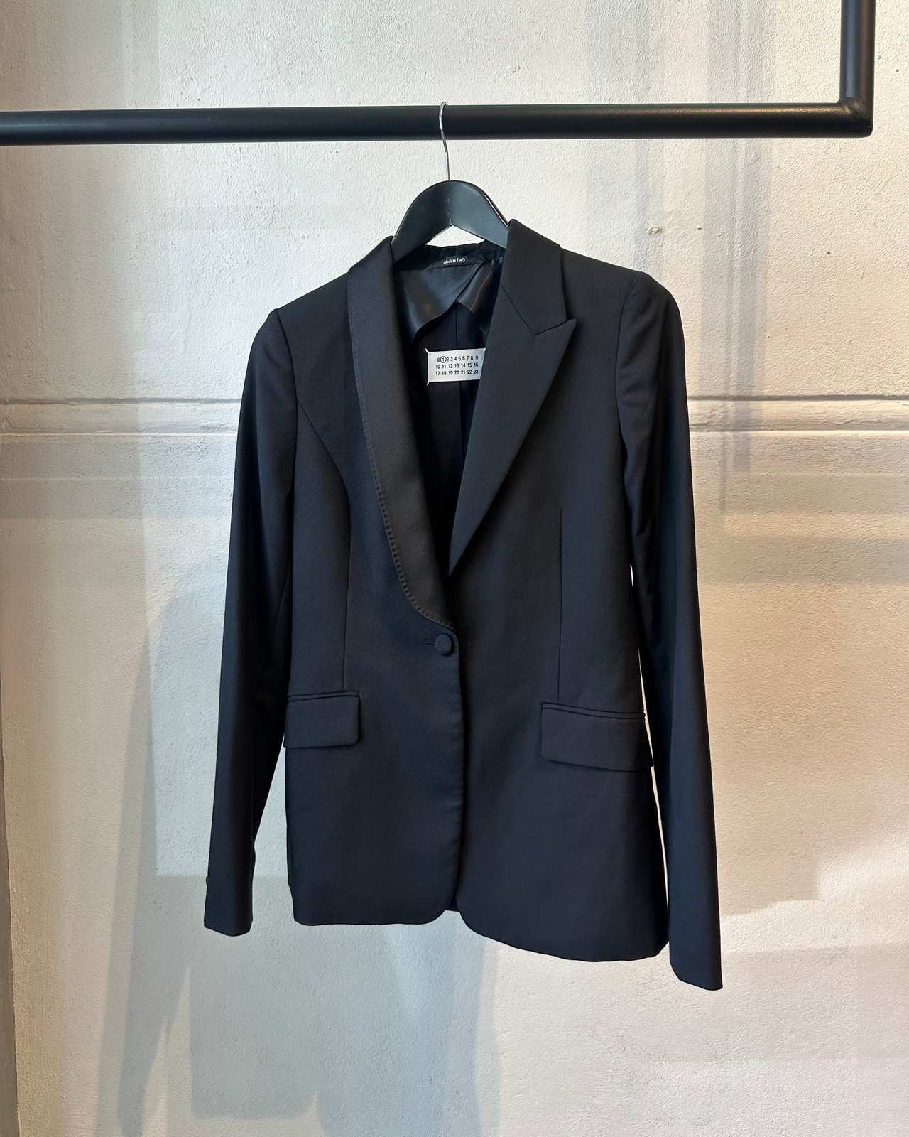 Black Maison Margiela blazer on a hanger against a neutral background