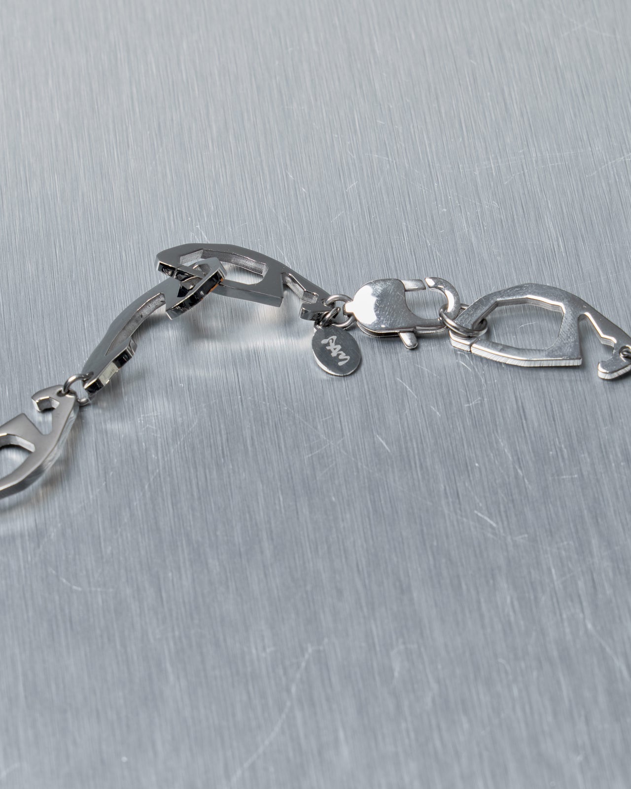 Silver Perks and Mini necklace on a textured gray background