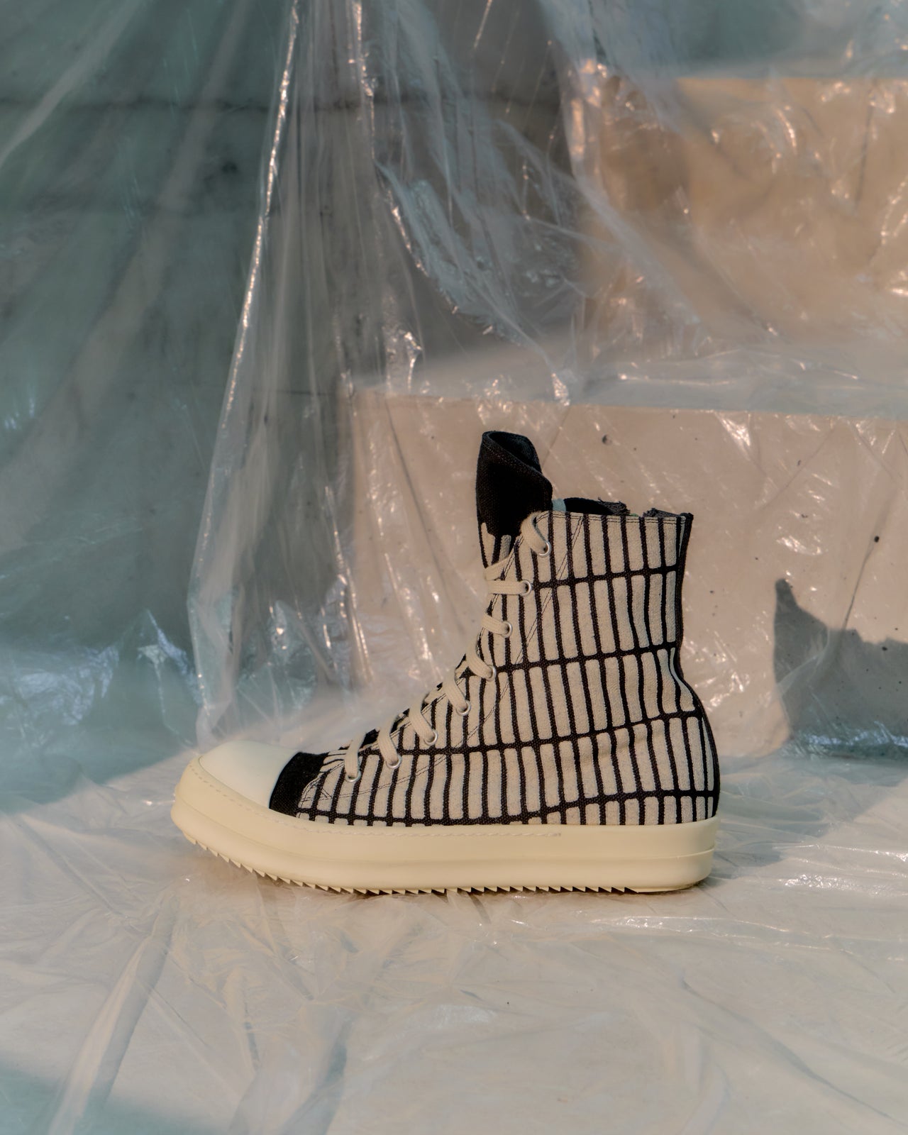 Black and white Rick Owens sneaker with grid pattern on a light background