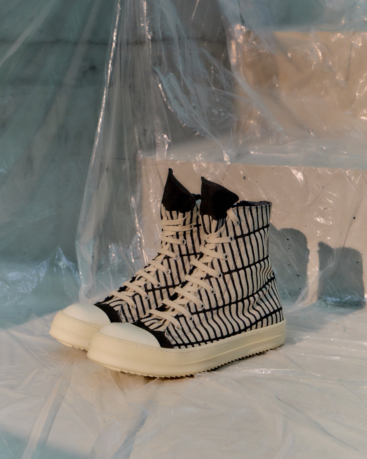 Black and white Rick Owens sneaker with grid pattern on a light background