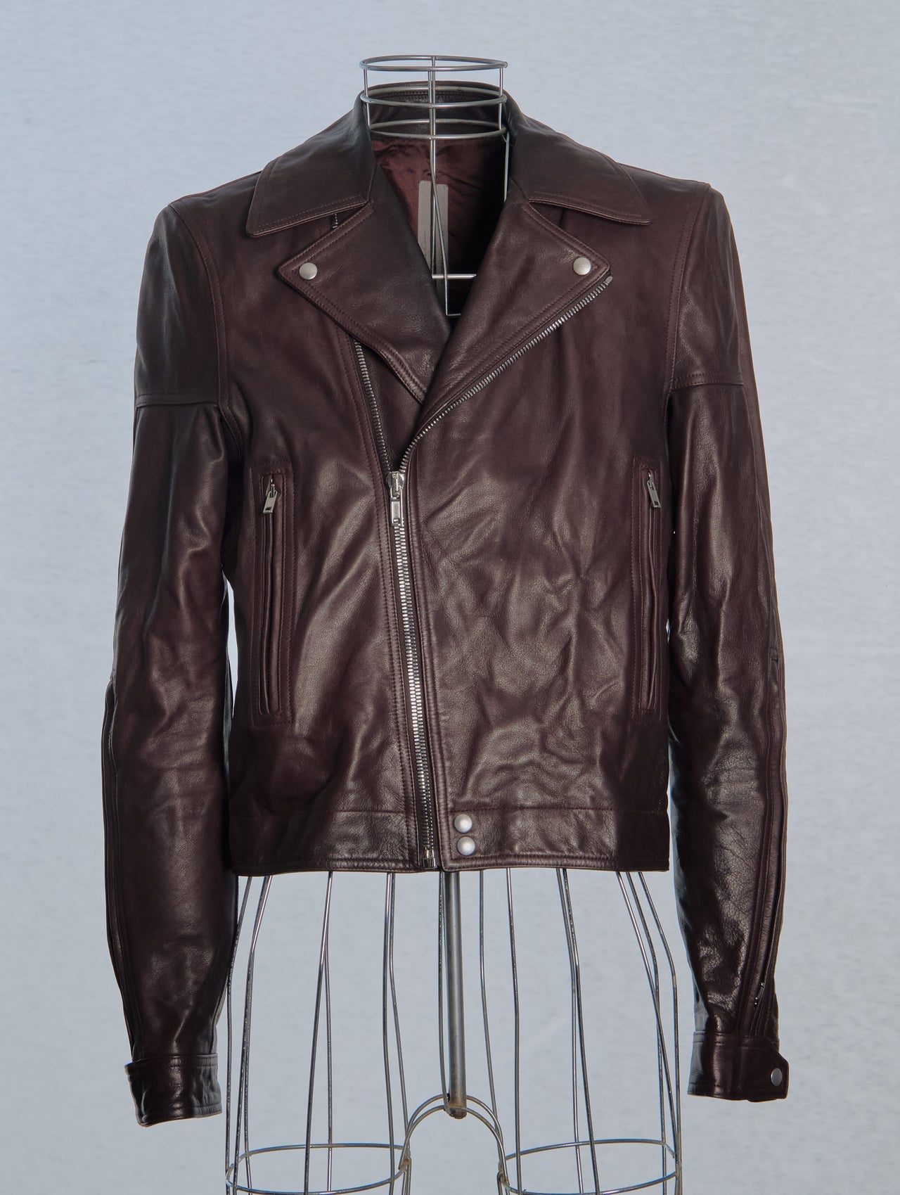Brown leather Rick Owens jacket on a mannequin against a gray background