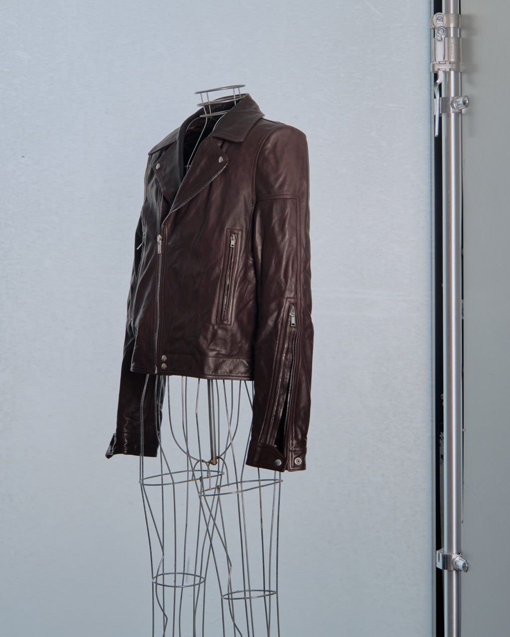 Brown leather Rick Owens jacket on a mannequin against a gray background