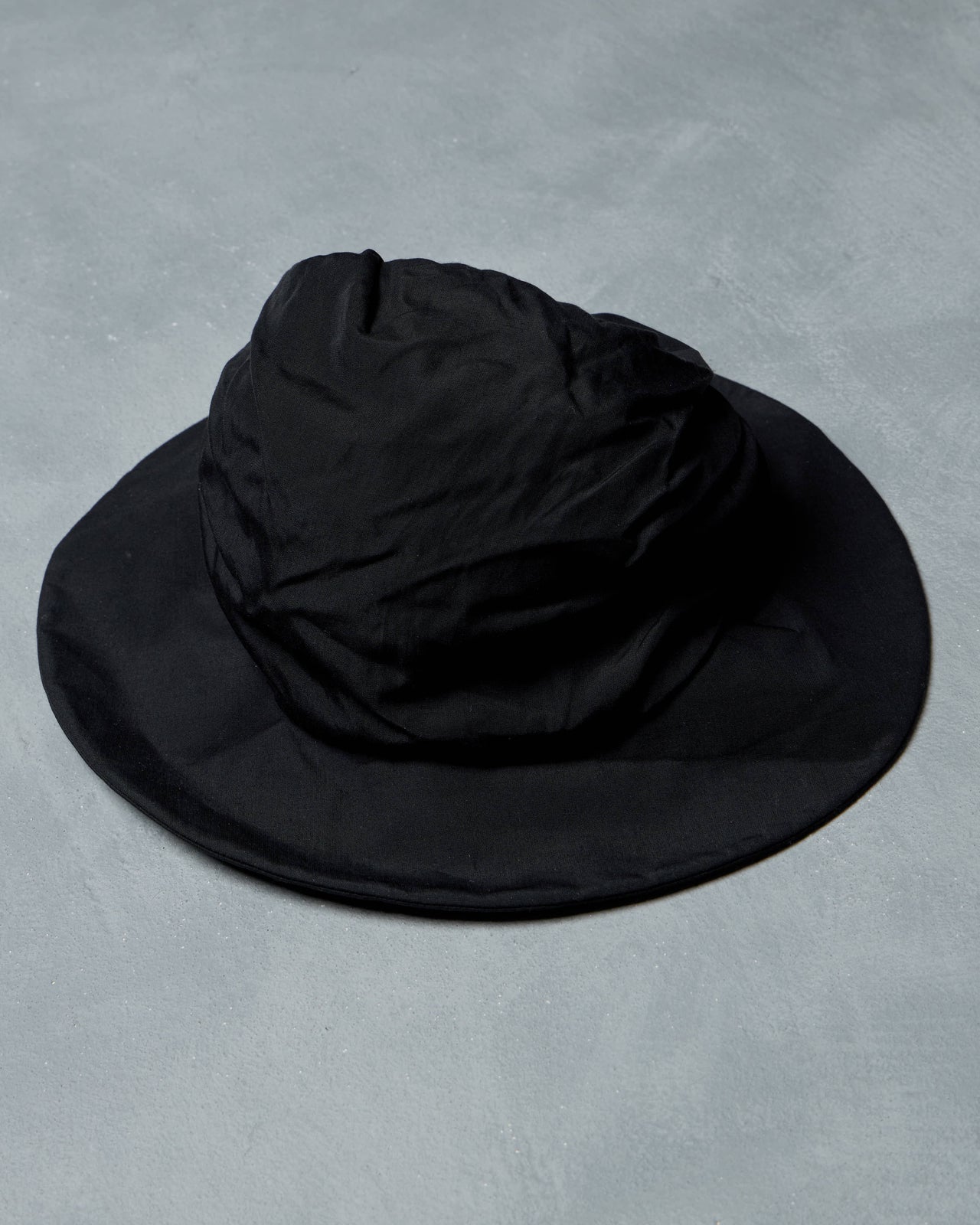 Black bucket Y's By Yohji Yamamoto hat on a gray background