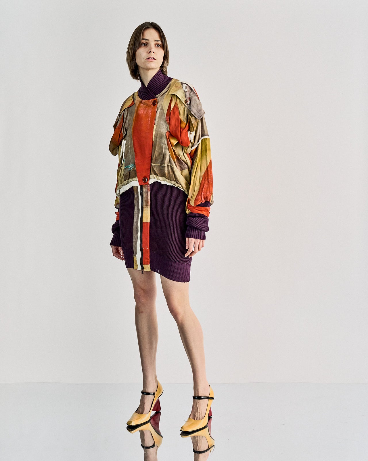A model poses in a colourful abstract Vivienne Westwood jacket. She wears two-tone high heels.