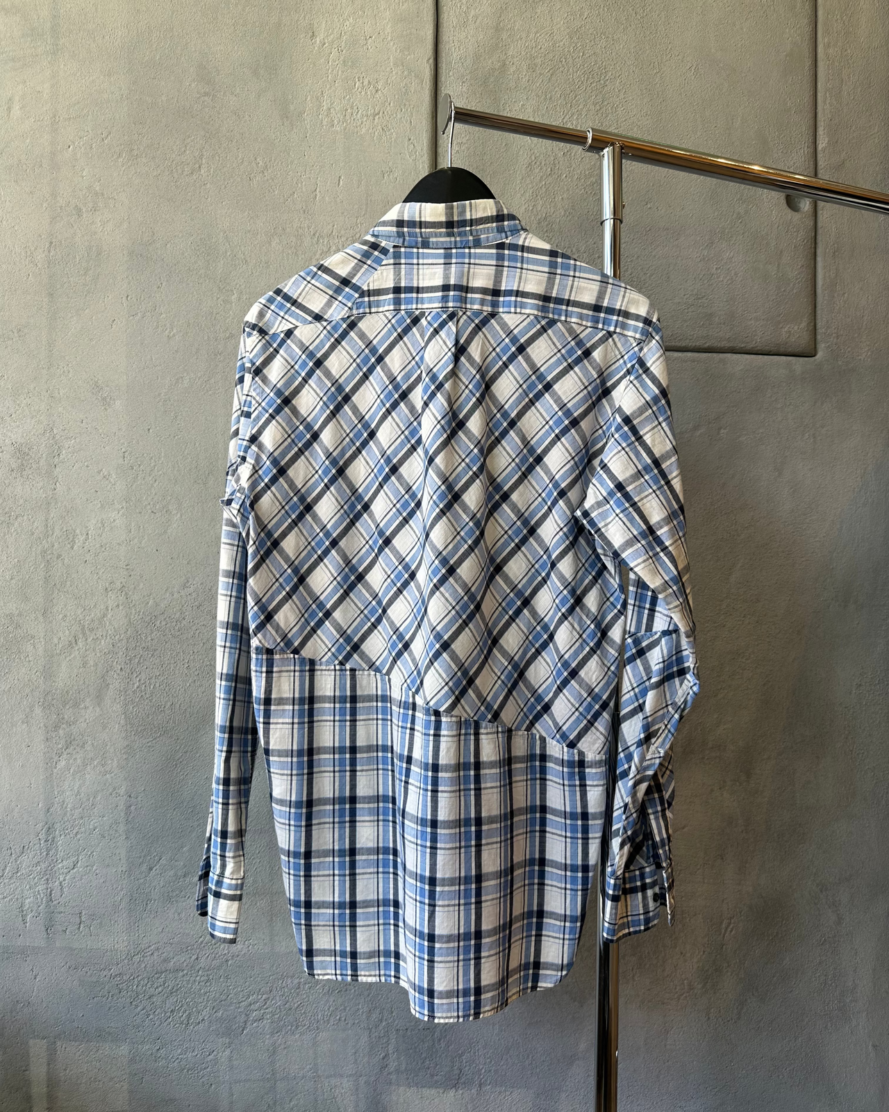 Blue and white AAR by Yohji Yamamoto plaid shirt on a hanger against a gray wall