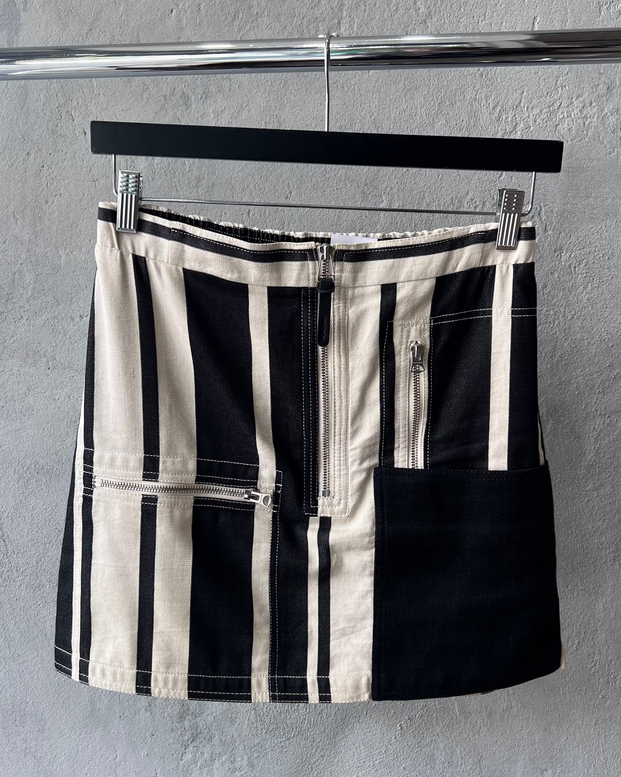 Black and white striped Acne Studios skirt on a textured surface