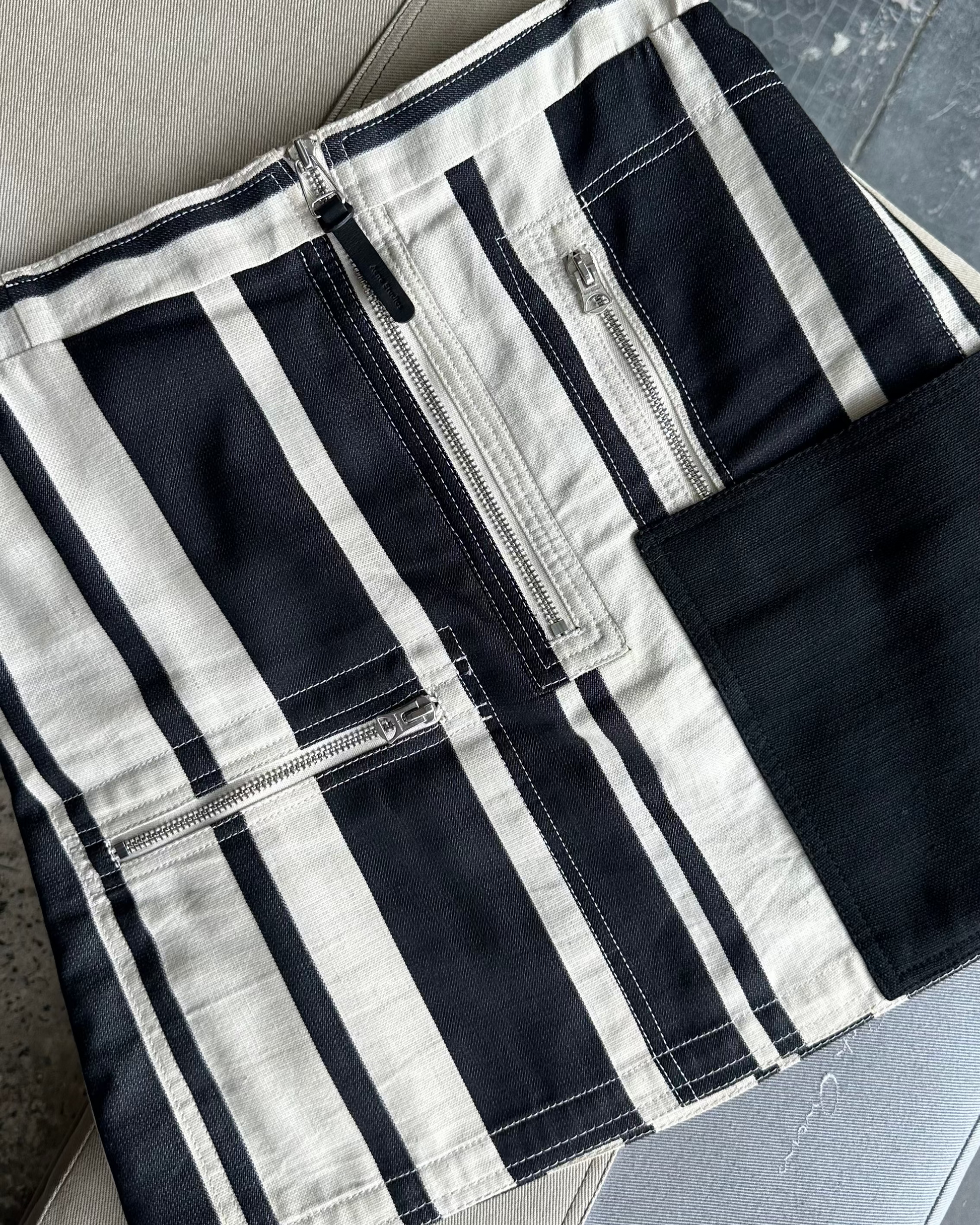 Black and white striped Acne Studios skirt on a textured surface