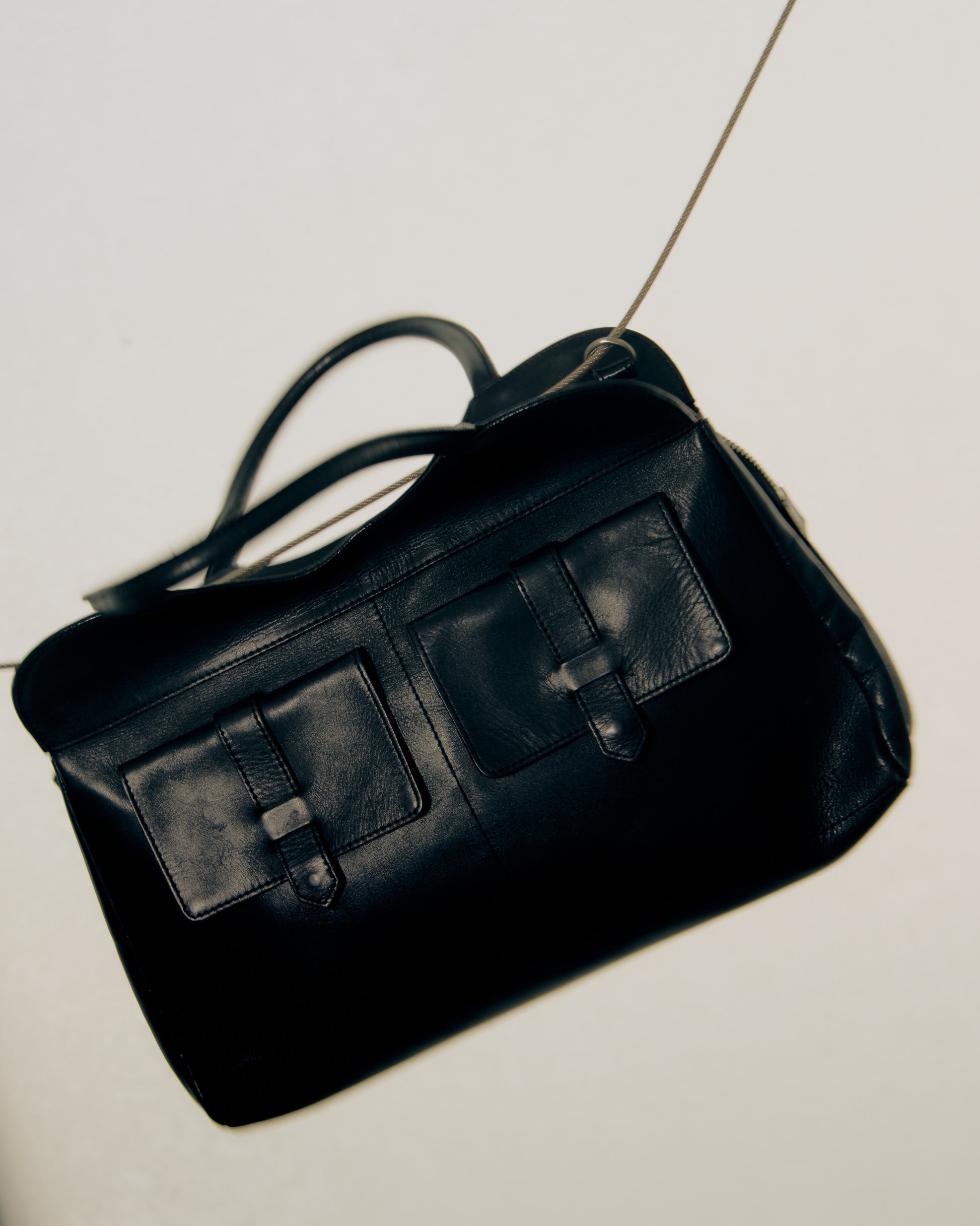 Black Alexander McQueen leather handbag on a light gray background
