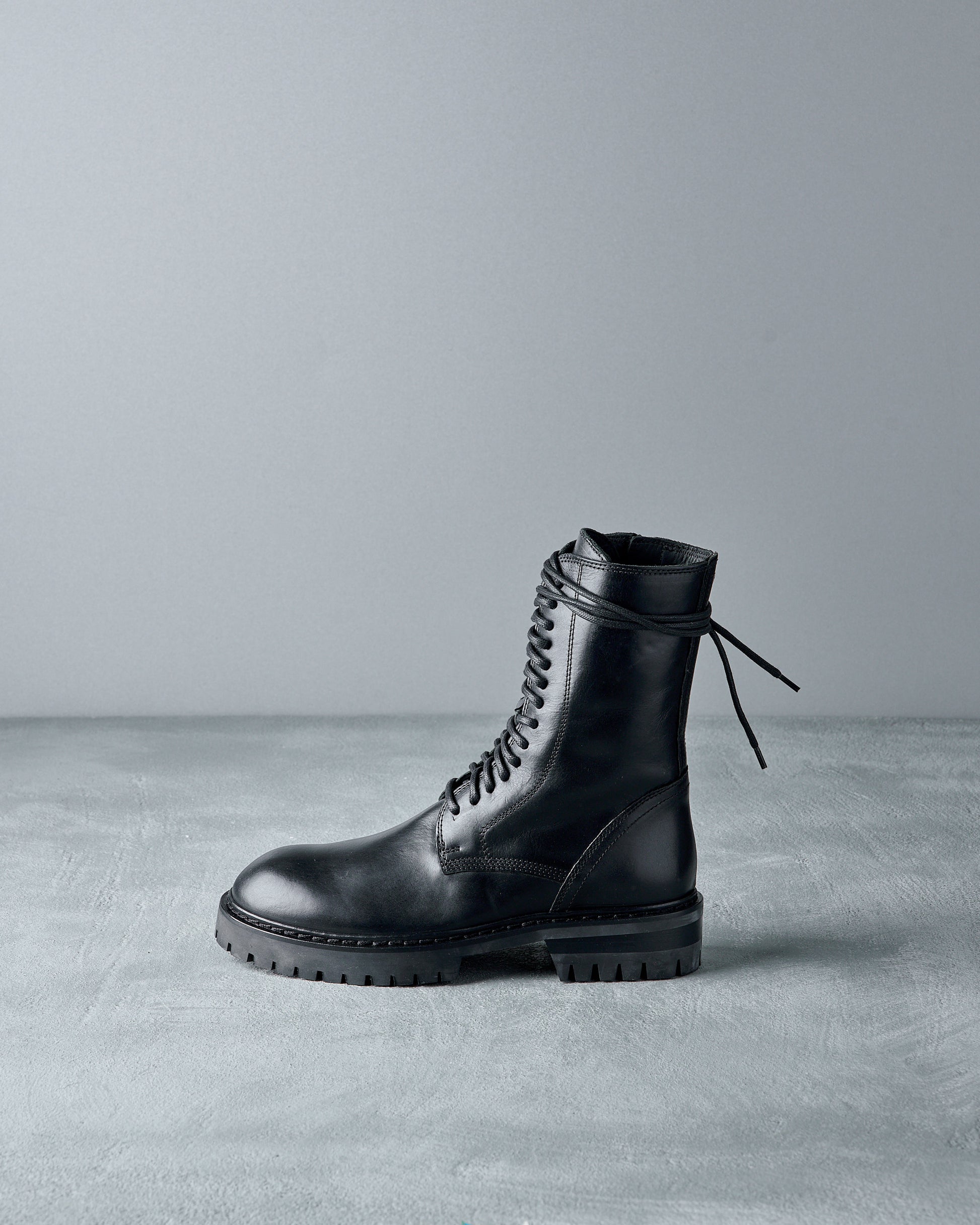 Black leather Ann Demeulemeester  boot on a gray background