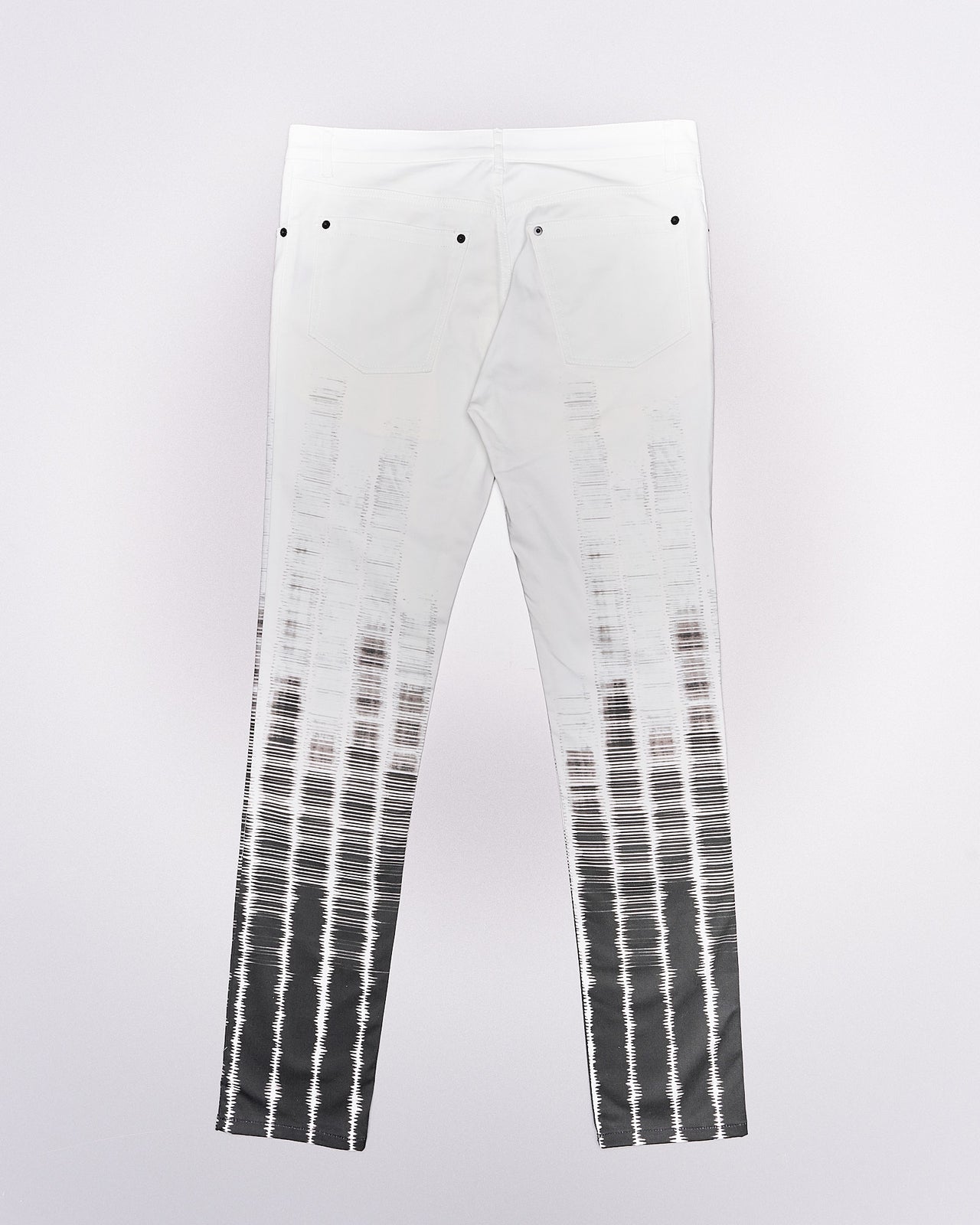 A pair of slim-fit Ann Demeulemeester tie-dye patterned trousers with button-fly closure and five-pocket styling, featuring contrasting press studs.