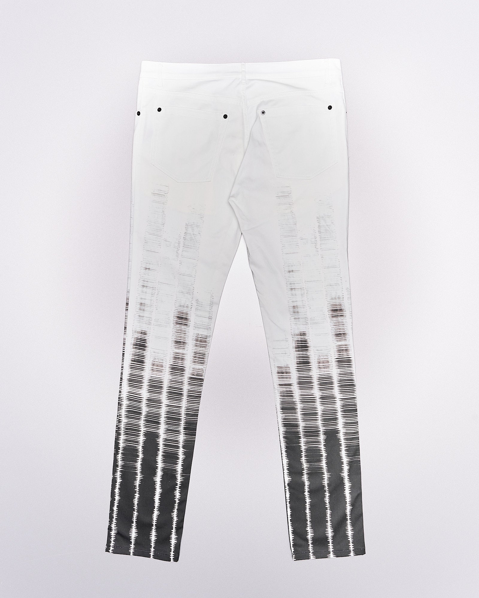 Reverse of a pair of slim-fit Ann Demeulemeester tie-dye patterned trousers with button-fly closure and five-pocket styling, featuring contrasting press studs.