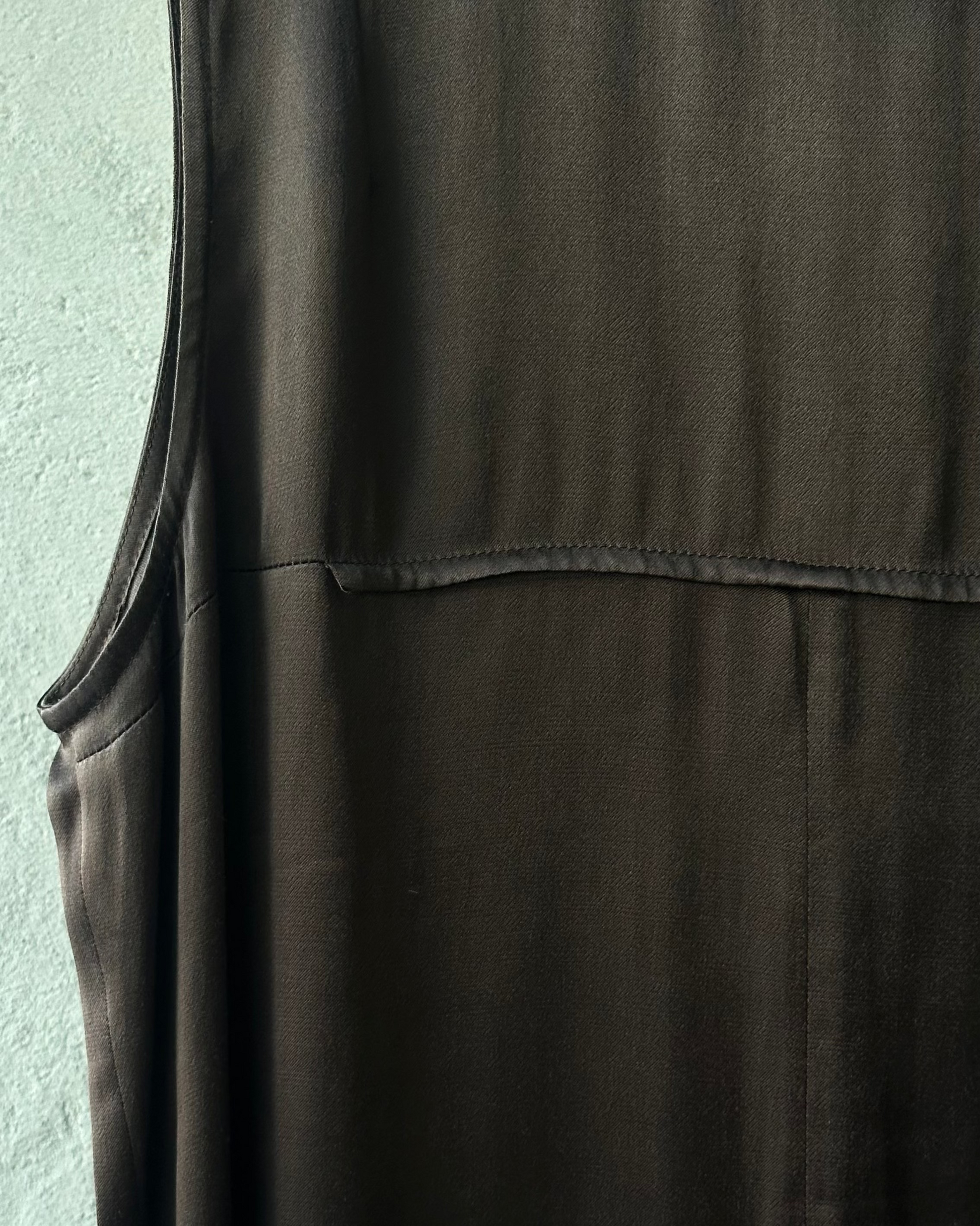 Dark brown sleeveless Ann Demeulemeester top against a light gray background