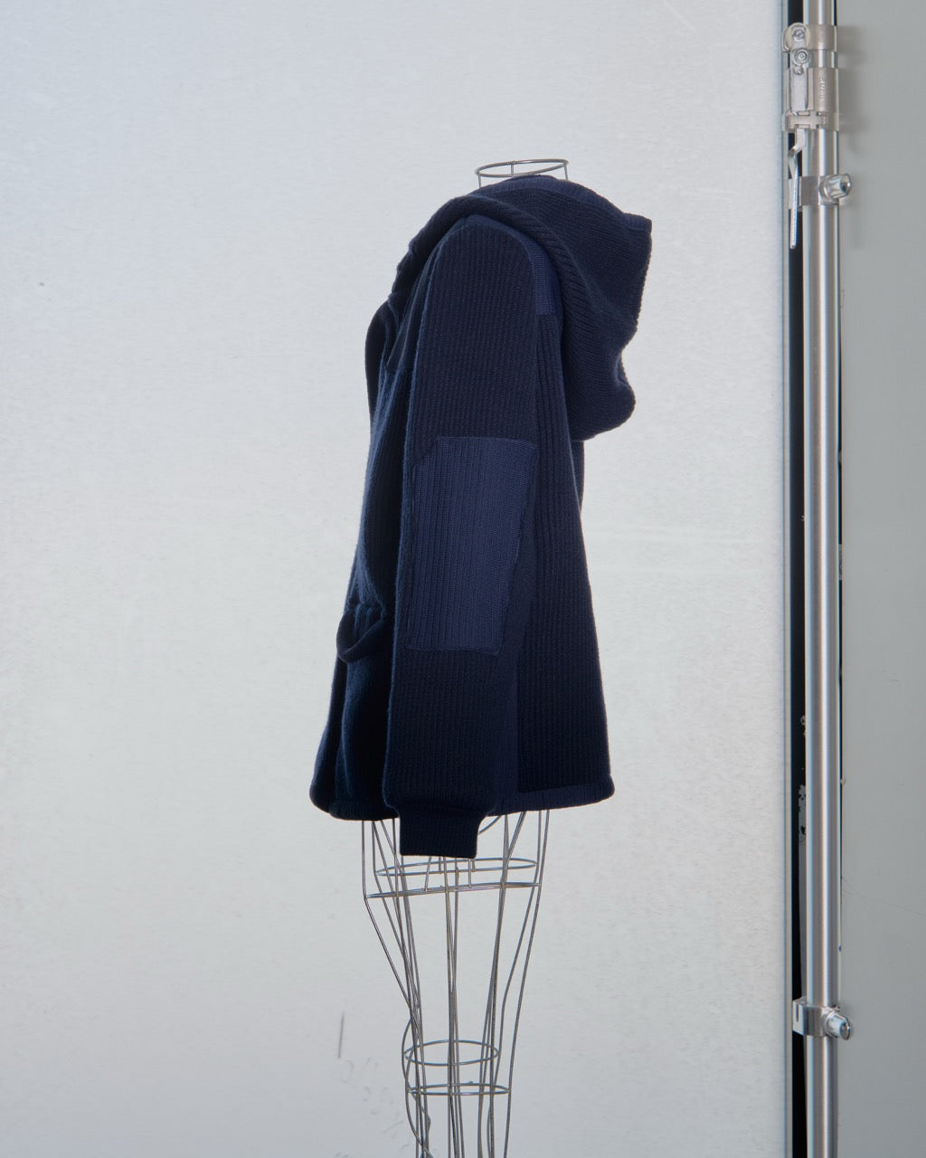 Navy blue Balenciaga sweater on a mannequin against a white background