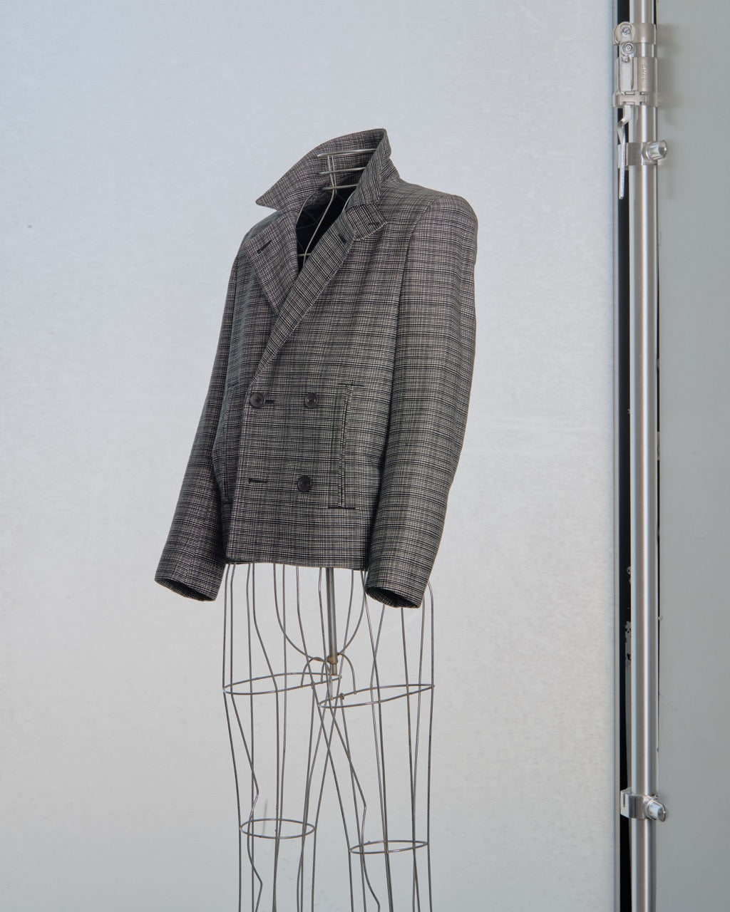Plaid Balenciaga blazer on a mannequin against a light gray background