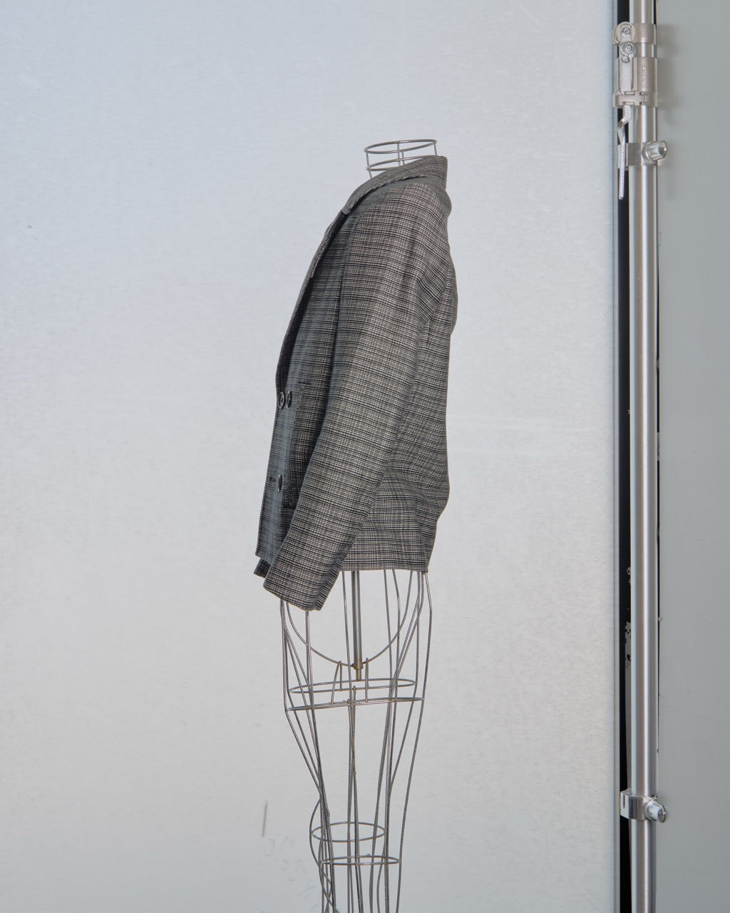 Gray checkered Balenciaga blazer on a mannequin against a white background