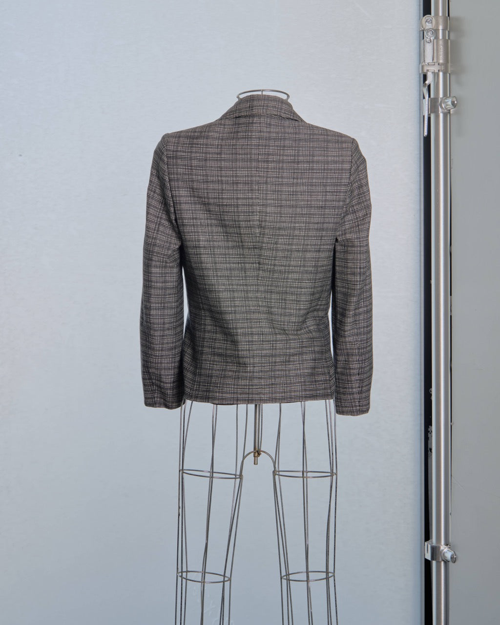 Plaid Balenciaga blazer on a mannequin against a light gray background