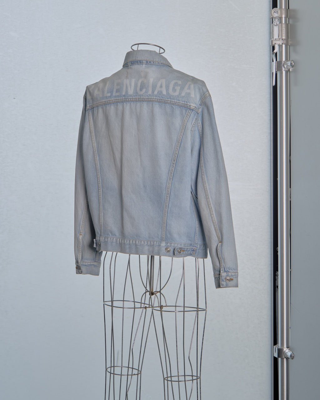 Light blue denim Balenciaga jacket on a mannequin against a plain background